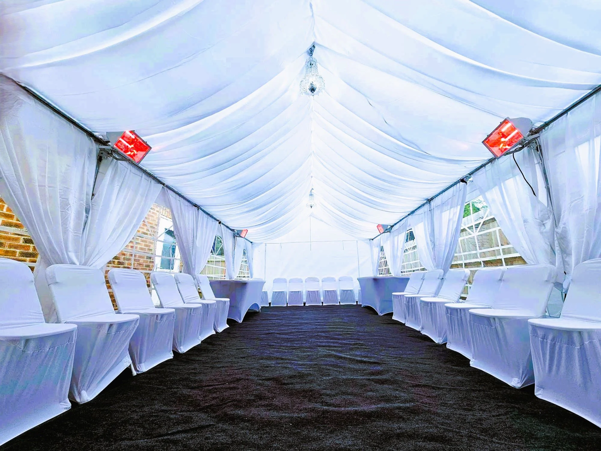 Elegant wedding marquee interior with ceiling drapes and lighting by NK Marquees – marquee hire Northampton, Milton Keynes and Bedford