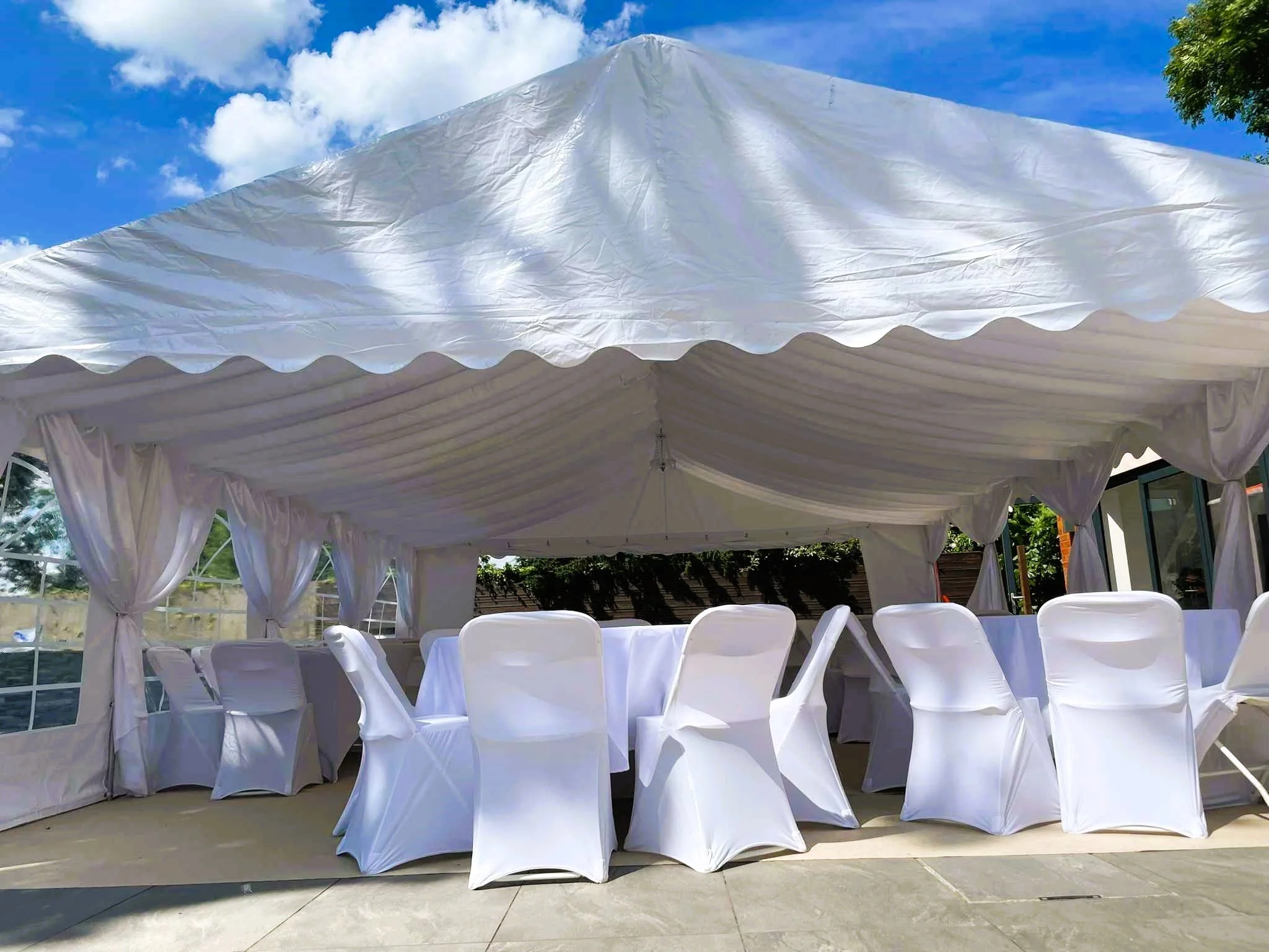 Marquee hire Northampton setup with tables, chairs and draped interior for events
