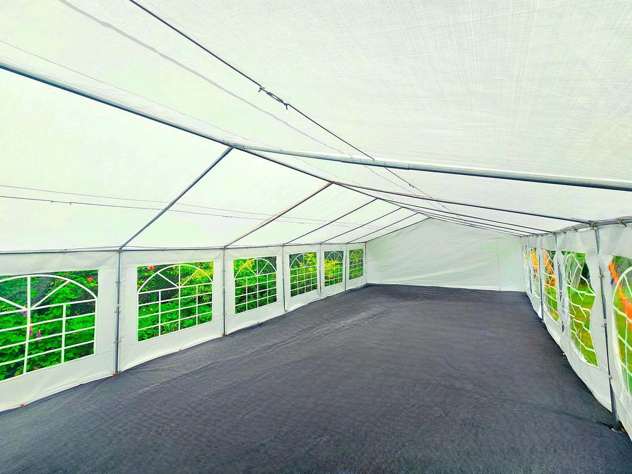 Spacious marquee interior with flooring and window panels ready for corporate event setup