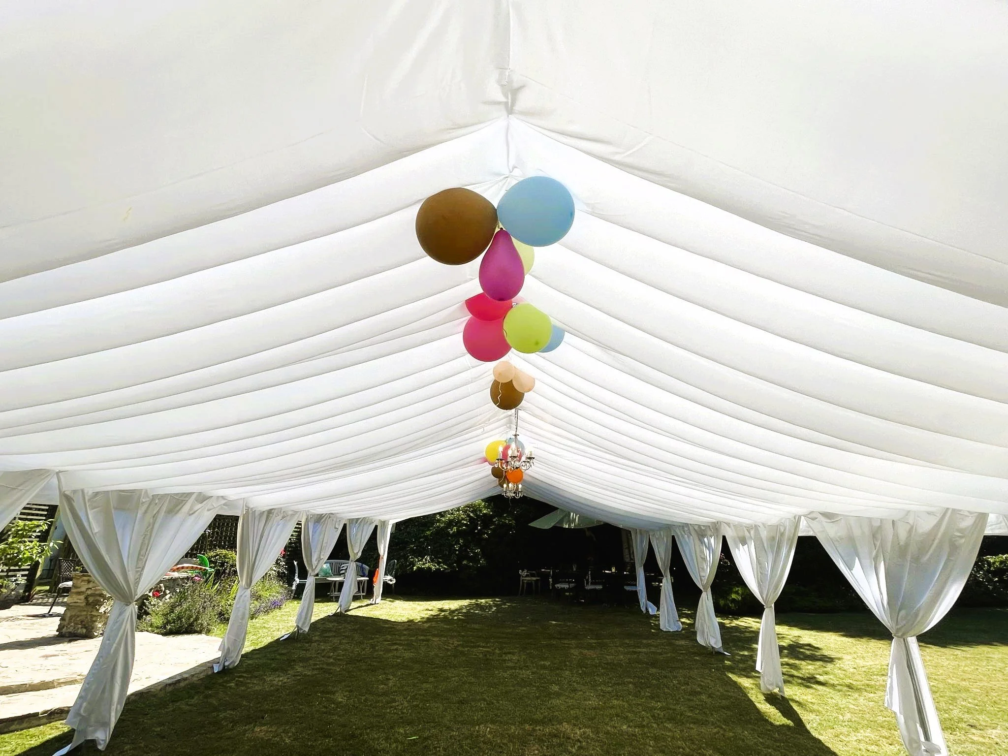 Party marquee hire setup with draped ceiling and balloons for celebration – NK Marquees