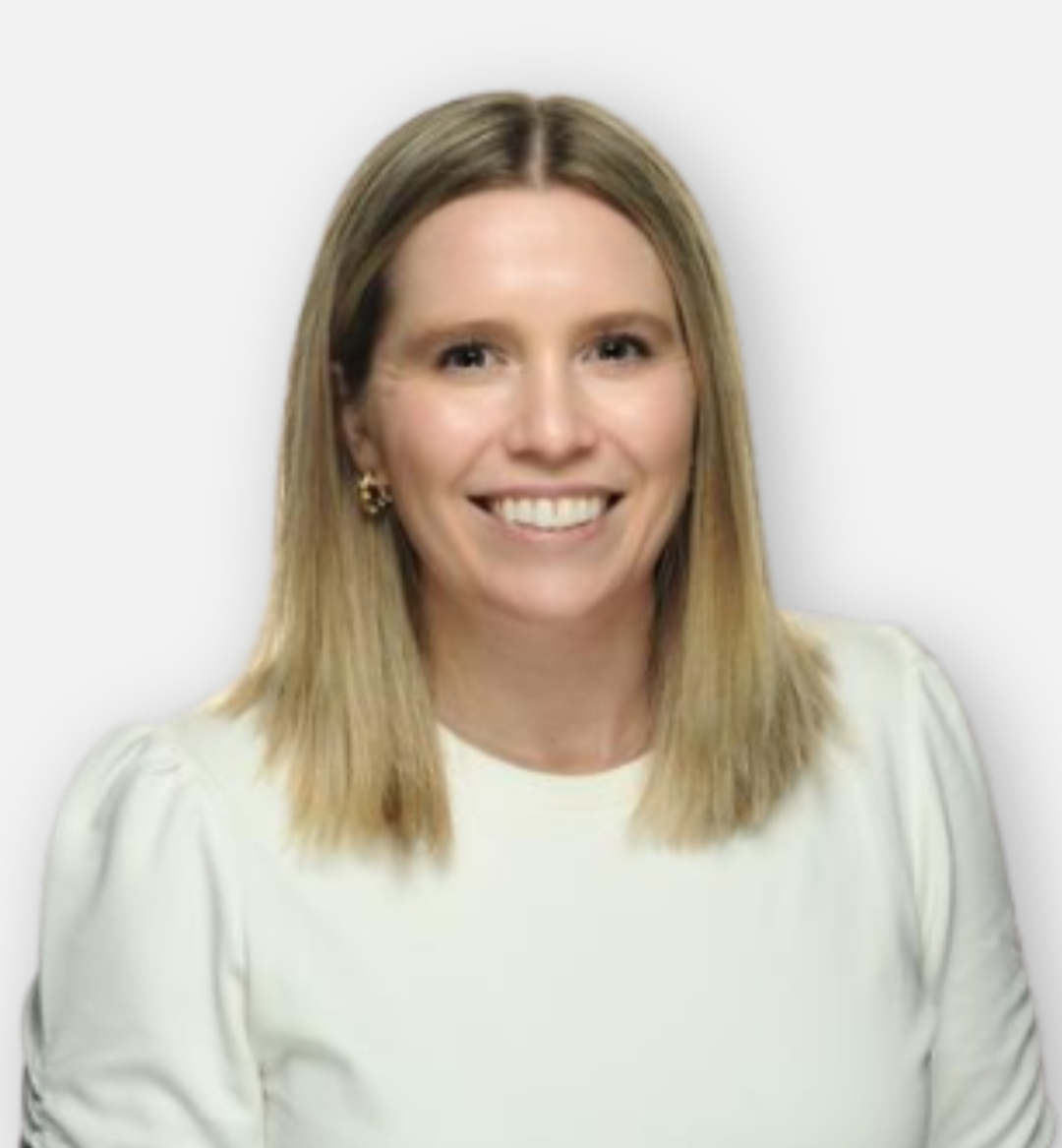 A woman with shoulder-length blonde hair, smiling, wearing gold earrings and a cream-colored top, against a plain white background.