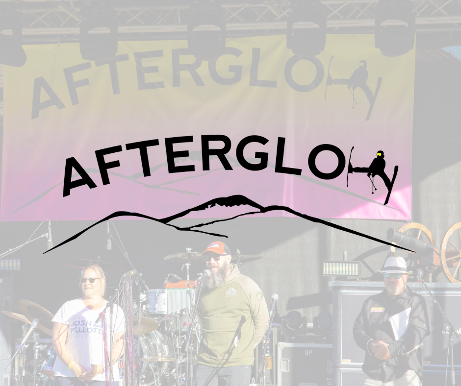People standing on stage at the Afterglow event, with a large colorful banner displaying the event name and mountain silhouette in the background.