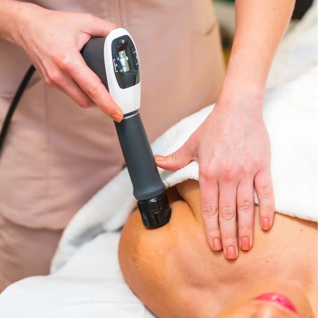 A person receiving a treatment with a handheld device on their knee, part of a medical or therapeutic procedure.