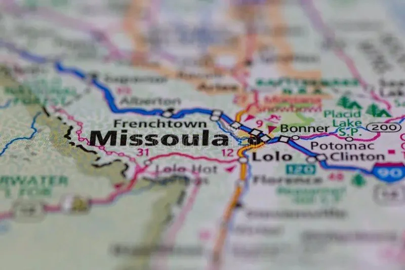 Close-up of a colorful map highlighting Missoula, Montana, and surrounding towns, roads, and landmarks.