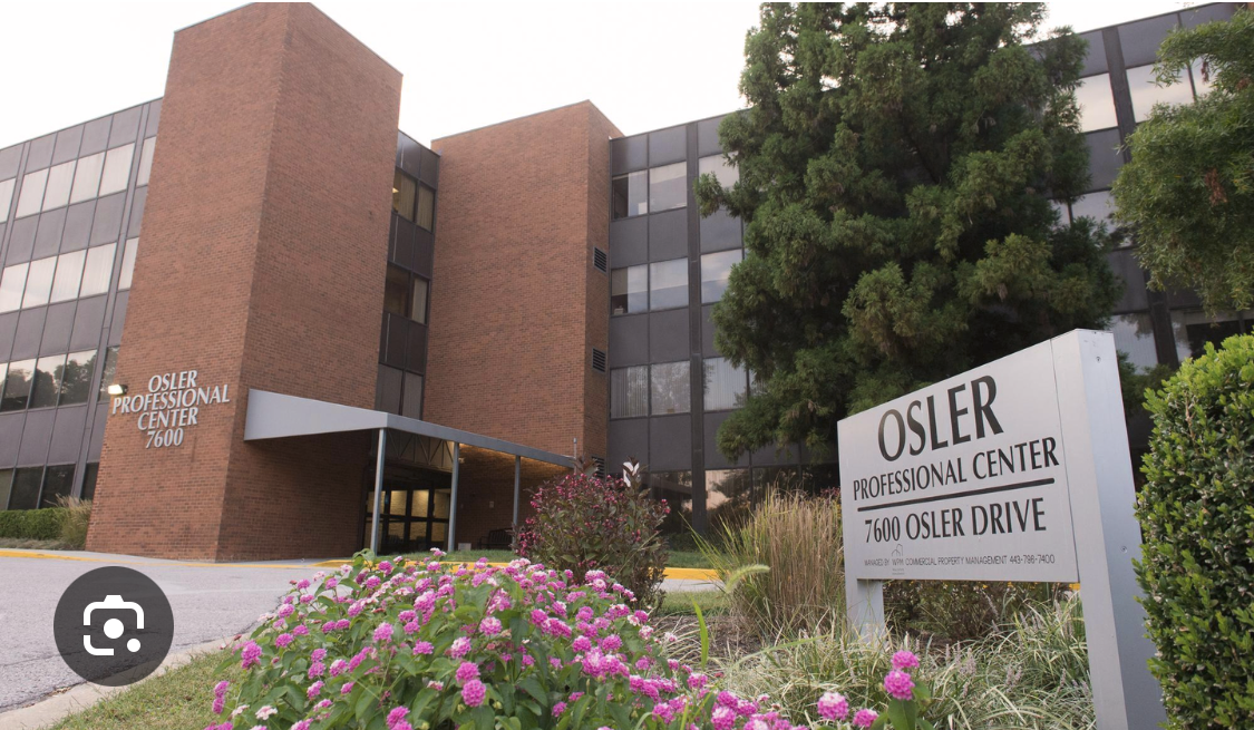 Exterior view of Osler Professional Center building with sign indicating address at 7600 Osler Drive and a flower bed with pink and purple flowers in front. best chiropractor in Towson, low back pain, chiropractor for athletes, five star chiropractor