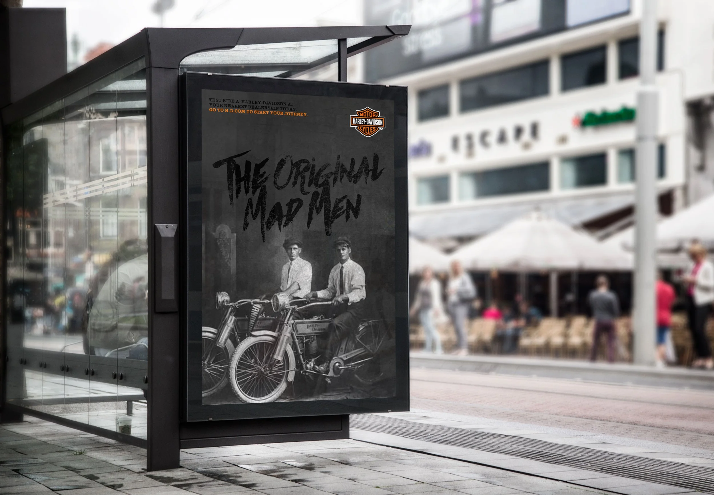 Black and white poster advertising Harley-Davidson motorcycles, featuring two vintage motorcycles and two men sitting on them, with the text "The Original Mad Men".