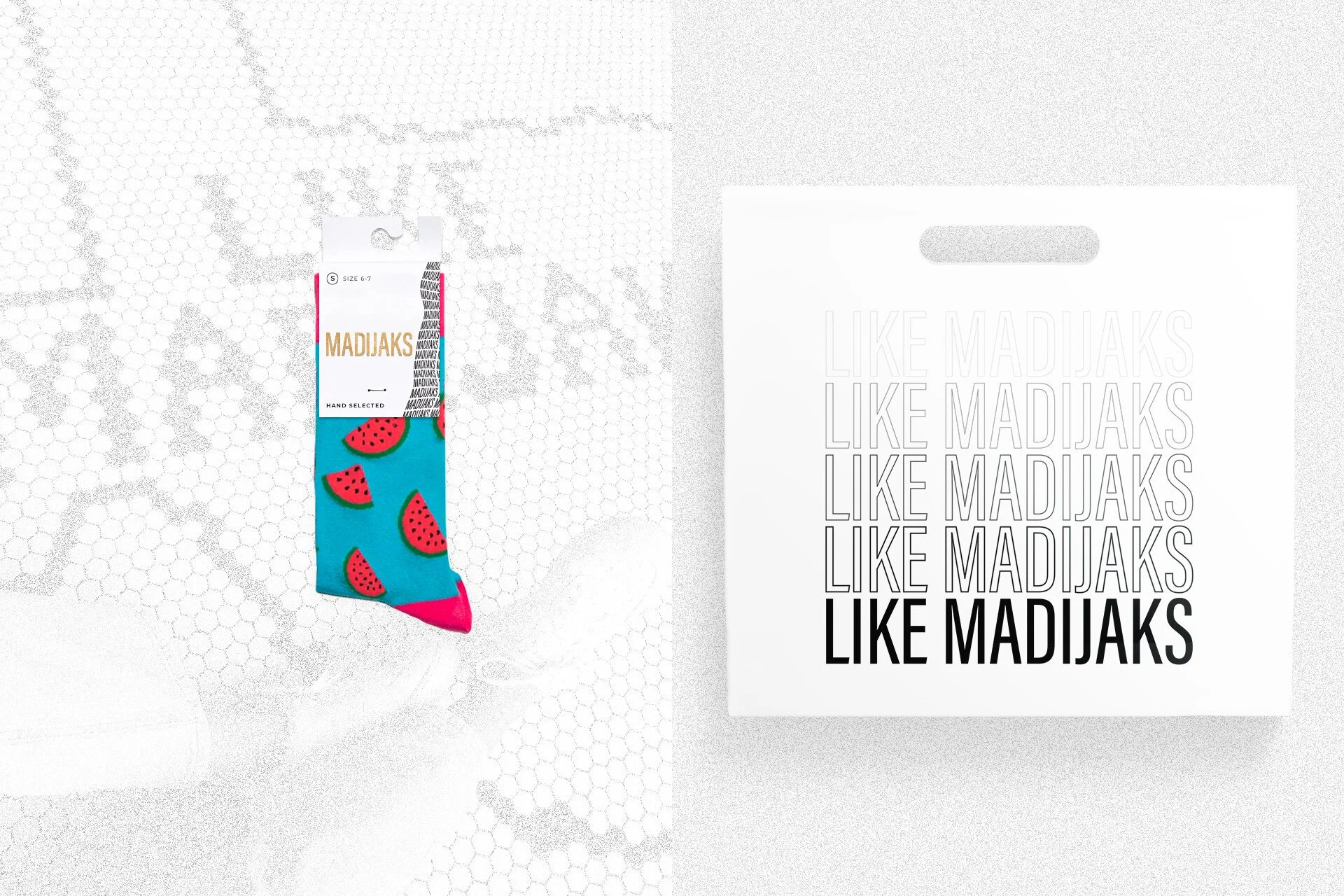 Colorful socks with a watermelon pattern displayed next to a white sign with repeated black and gray text reading "LIKE MADJAKS."