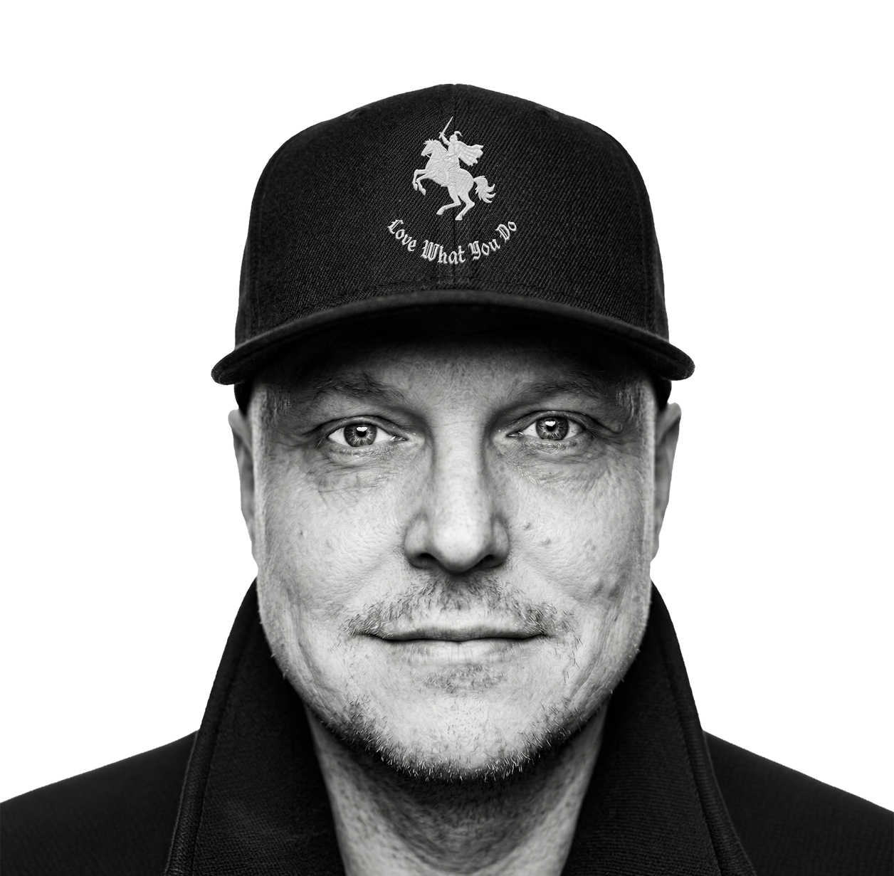 Black and white close-up portrait of a man wearing a cap with a unicorn and sword logo and the text "Love What You Do."