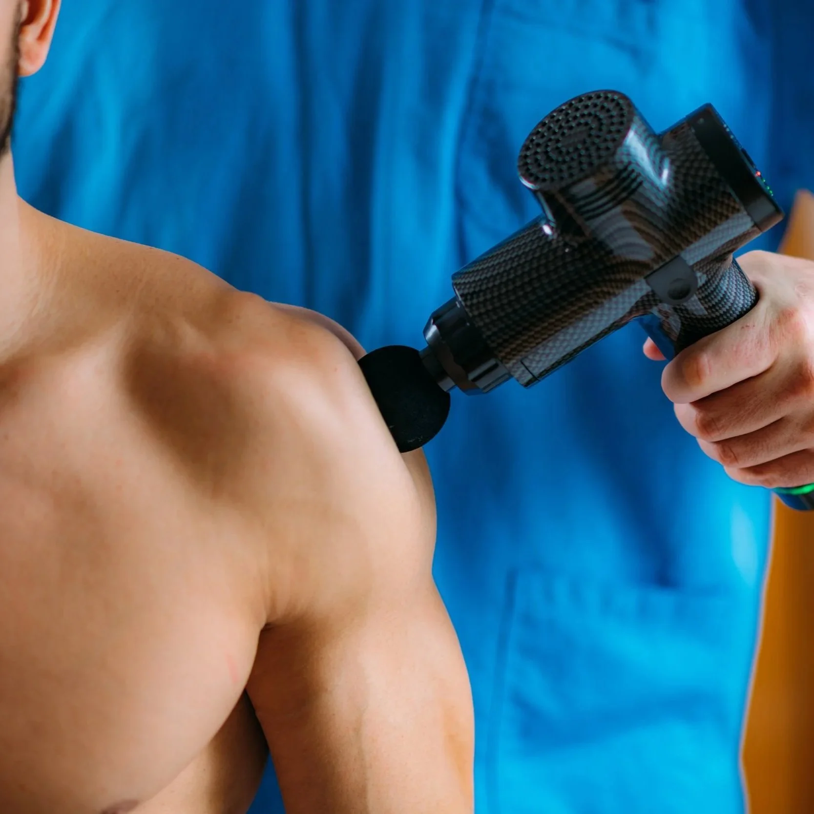 therapist-treating-man-s-shoulder-with-massage-gun.jpg