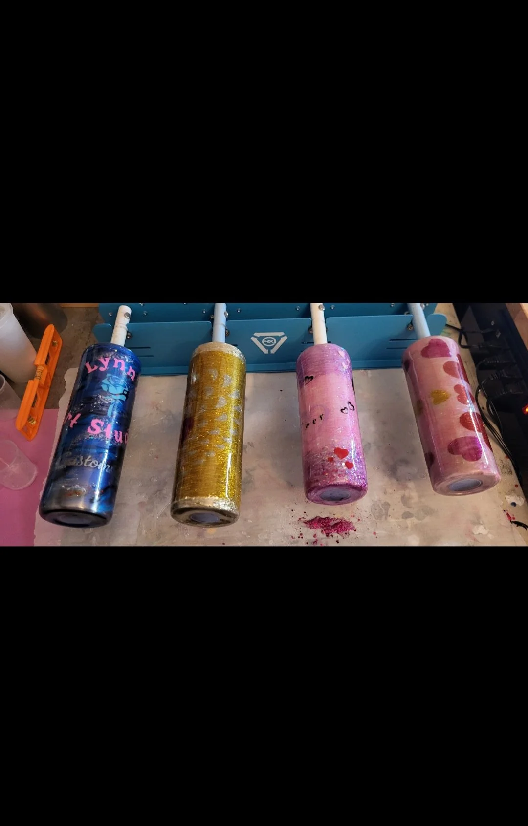 Four rolls of decorative wrapping paper with various colors and patterns, placed on a table.