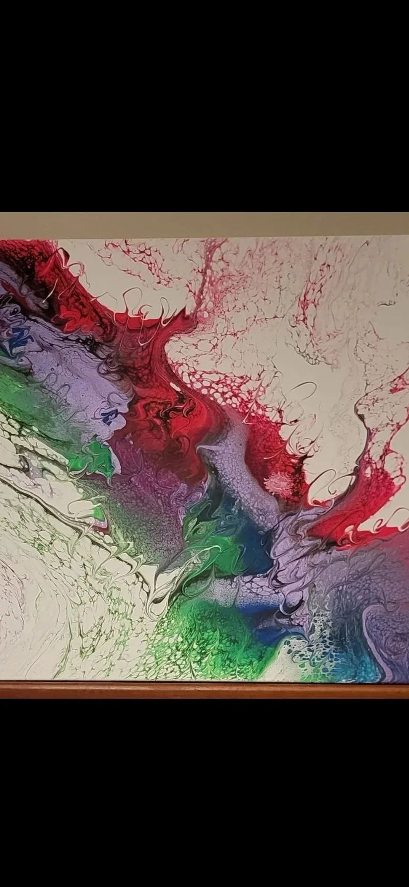 Abstract colorful fluid art painting with swirls and patterns in red, purple, green, blue, and white on canvas.