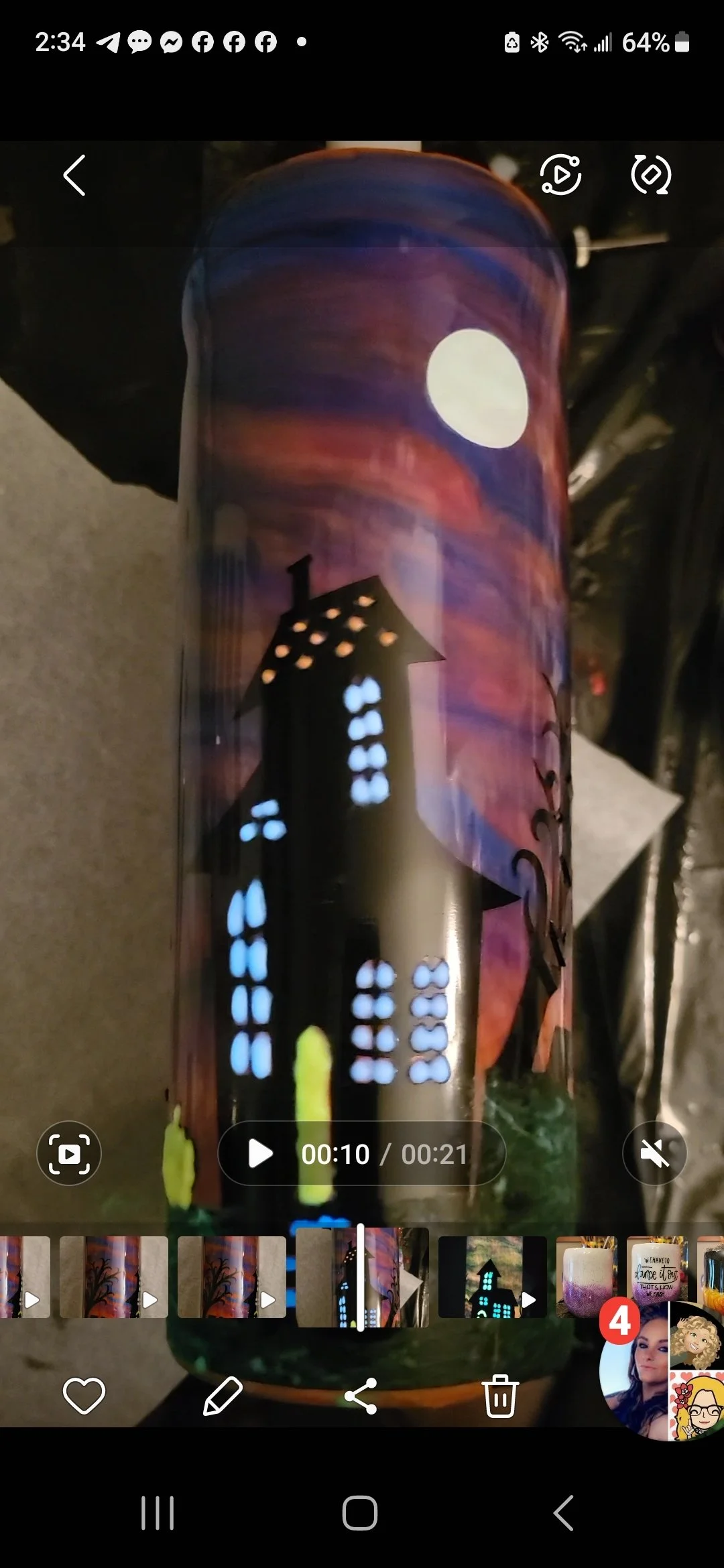 A painted metal can has a silhouette of a haunted house with glowing windows, a full moon in the night sky, and colorful swirling clouds in the background.