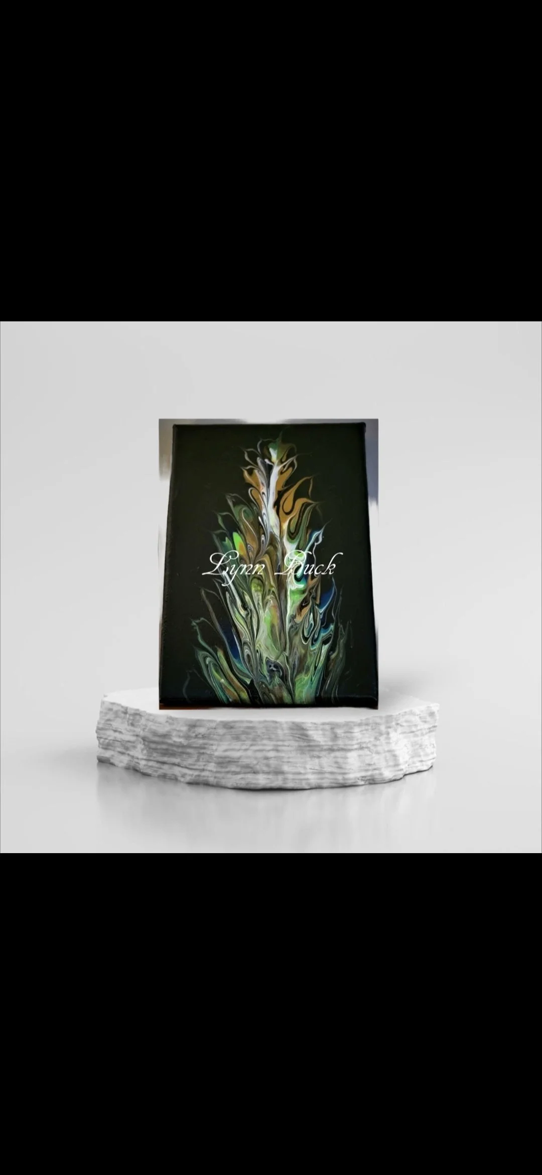 A black book with colorful, abstract swirling patterns on the cover, placed on a white textured platform, with the name 'Lyyen Duck' written on it.