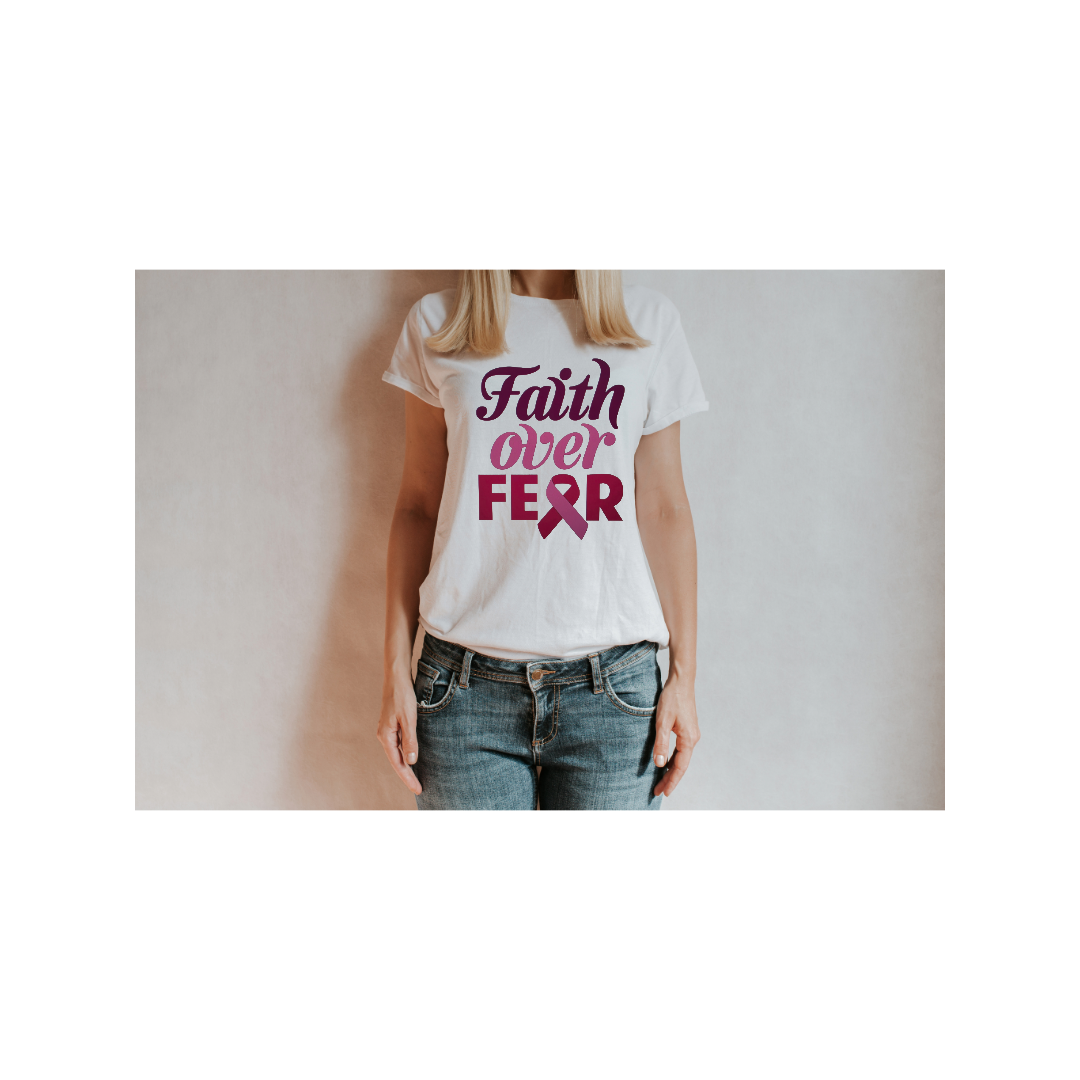 Woman wearing a white T-shirt with pink and purple text that reads 'Faith Over Fear' and a pink awareness ribbon, standing against a neutral background.