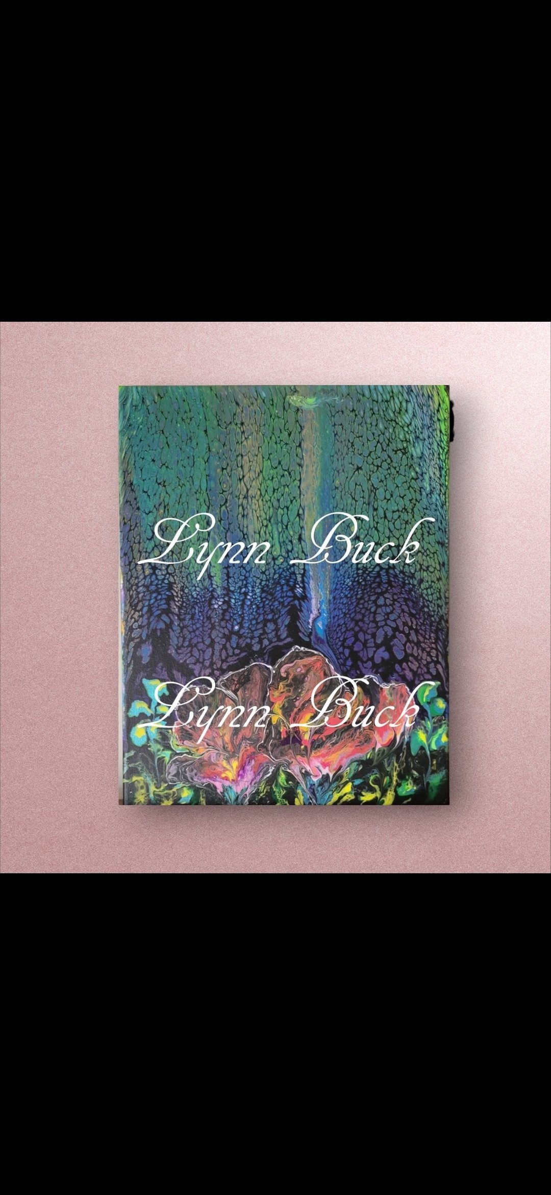 A book titled 'Lynn Buck' with a colorful abstract cover is placed against a light pink background.