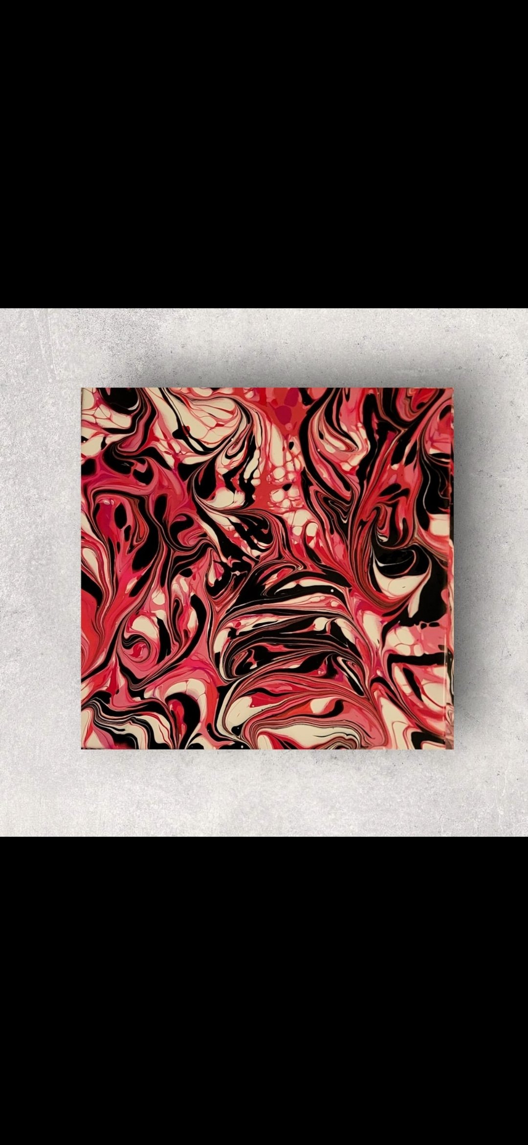 An abstract painting with swirling patterns in red, black, and white colors displayed on a wall.