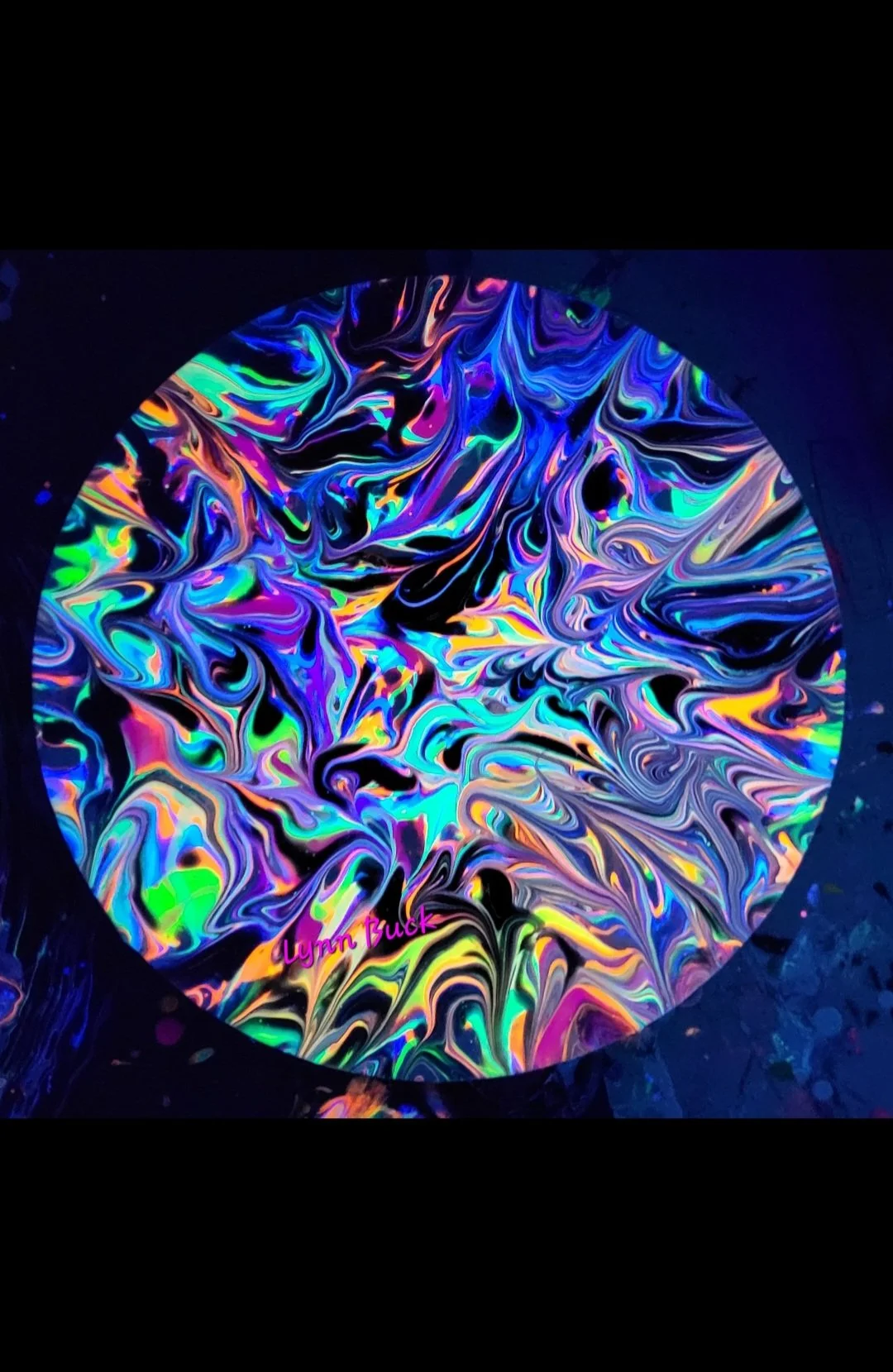 Colorful swirling abstract art on a circular surface, with the signature 'Lynne Buck' written in pink at the bottom.