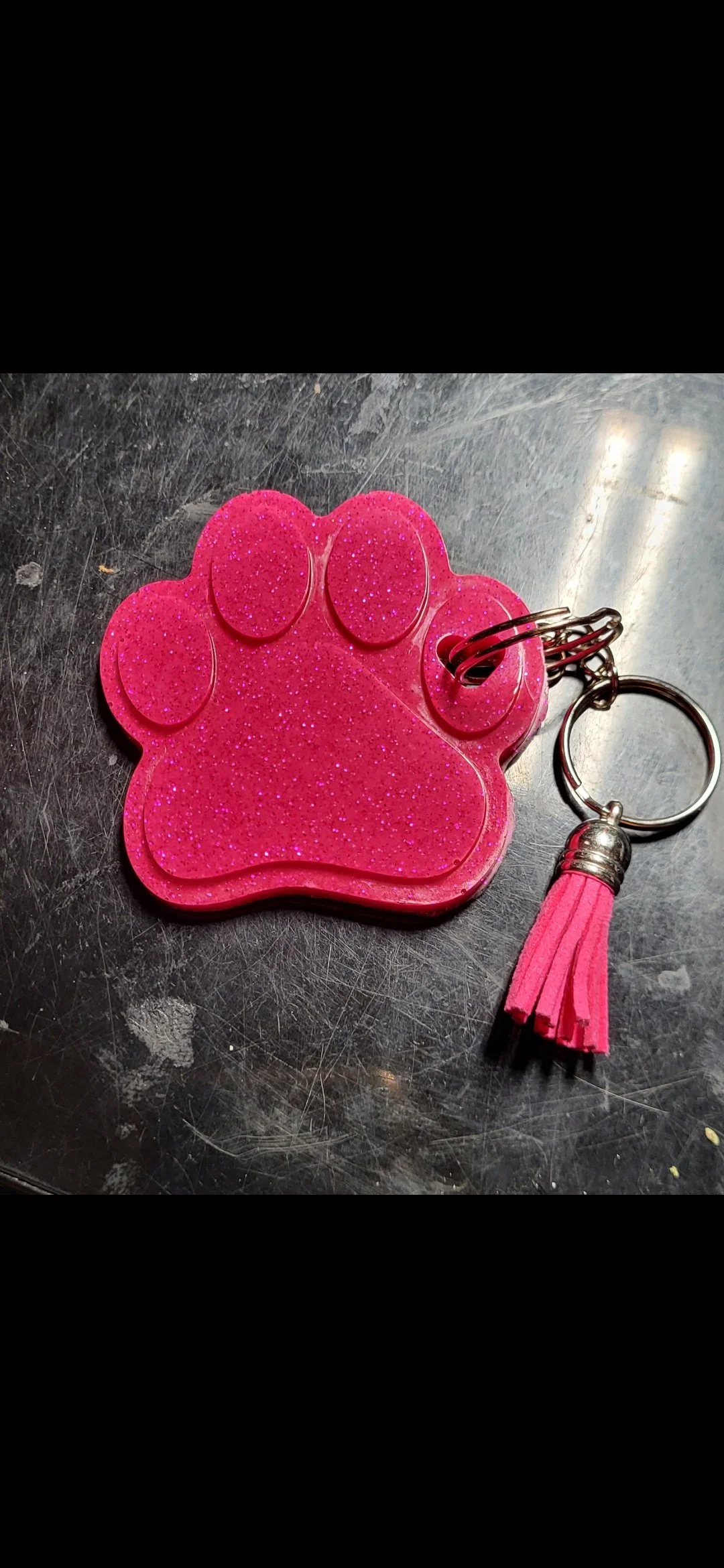 Pink glitter paw print keychain with a small pink tassel.