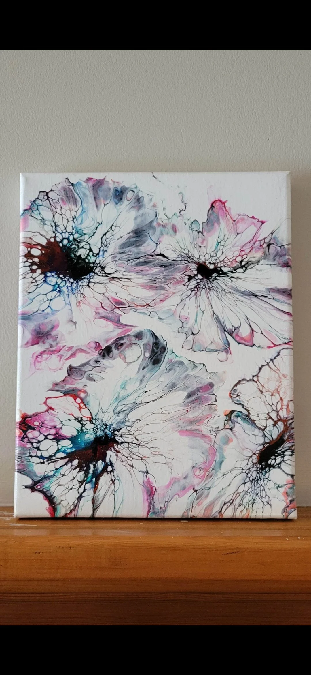 Abstract painting featuring butterfly wing patterns with black, pink, blue, and gray colors.