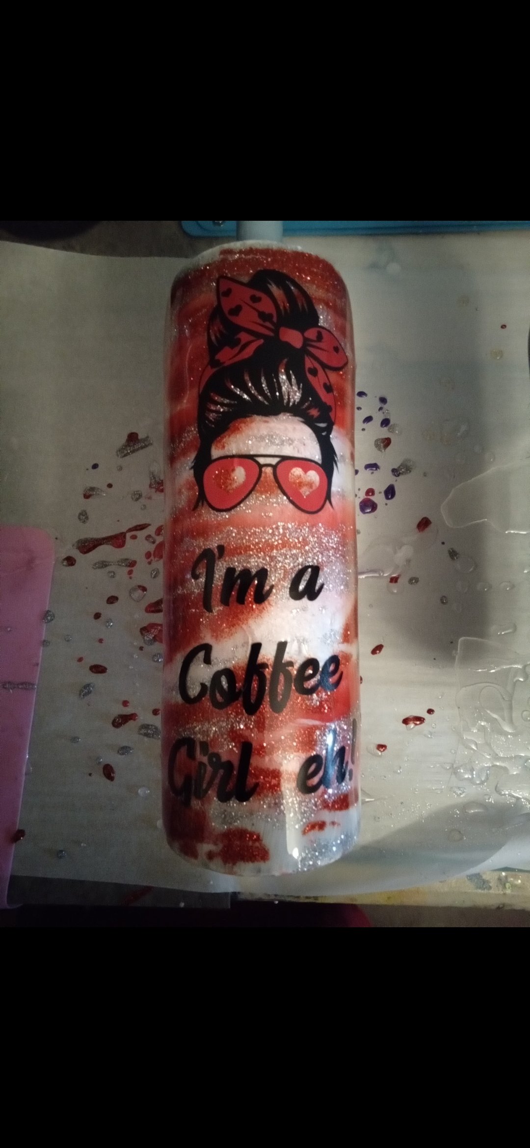 A tumbler decorated with a graphic of a woman with a bun hairstyle, sunglasses with heart-shaped lenses, and a bow in her hair. The text on the tumbler reads 'I'm a Cobee Girl' in black lettering, with red and white swirls and glitter. There are scat