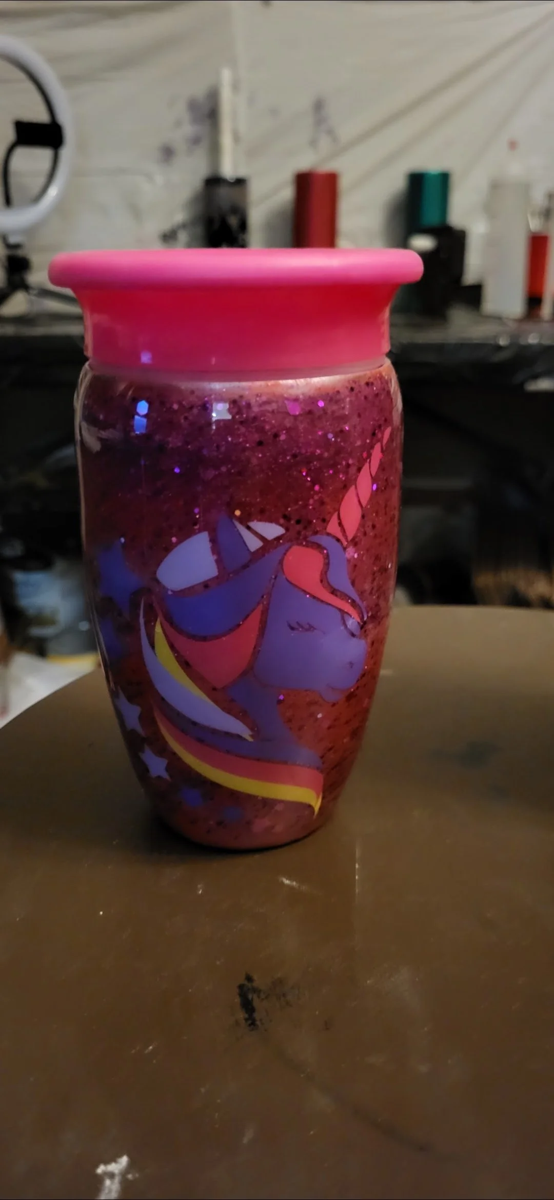 Glass jar with a pink lid, decorated with a Unicorn design and filled with red, glittery contents.