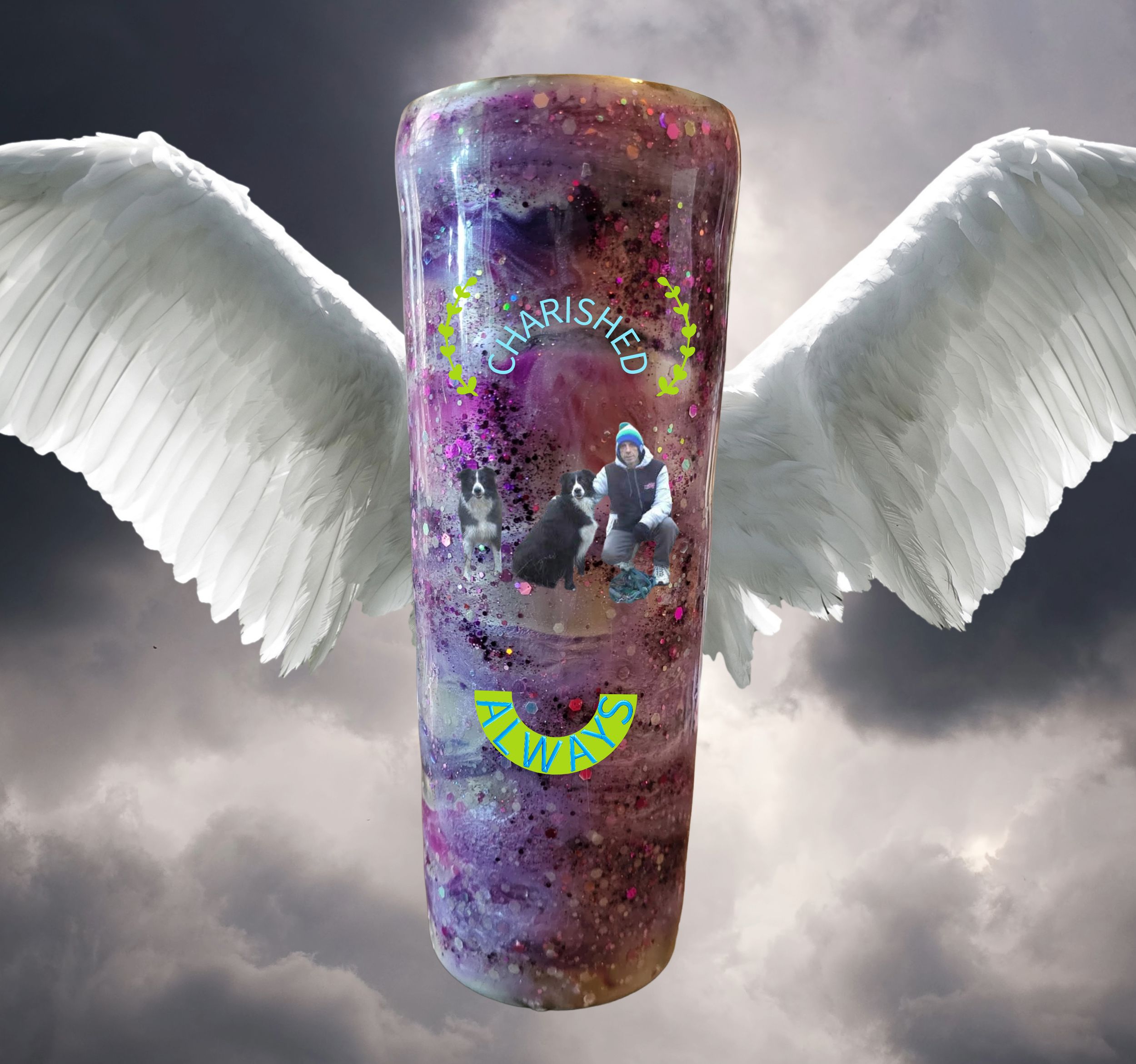 A colorful tumbler with cosmic design, displaying the words 'CHAIRED ALWAYS' and images of a man and two dogs, with white angel wings attached to the sides, against a cloudy sky background.