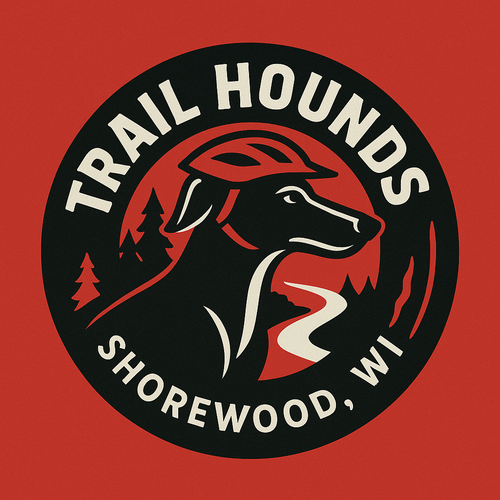Logo for Trail Hounds featuring a black dog wearing a red helmet, with trees and a winding trail in the background, and text "Trail Hounds Shorewood, WI"
