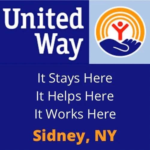 United Way logo with a hand holding a person with arms raised inside a circle, and text stating "It Stays Here, It Helps Here, It Works Here" and "Sidney, NY" in orange.