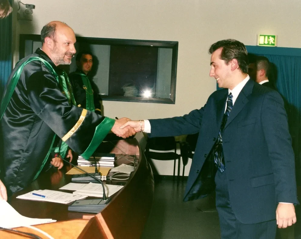 Andrea Stendardo | Senior full-stack engineer | Andrea Stendardo stringe la mano al Professor Alberto Coen Porisini durante la cerimonia ufficiale di laurea presso l'Università degli Studi dell'Insubria di Varese.