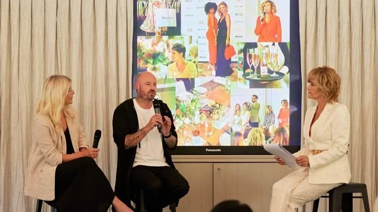 Three people sitting on stools in front of a large screen displaying various fashion and social images during a presentation or discussion.