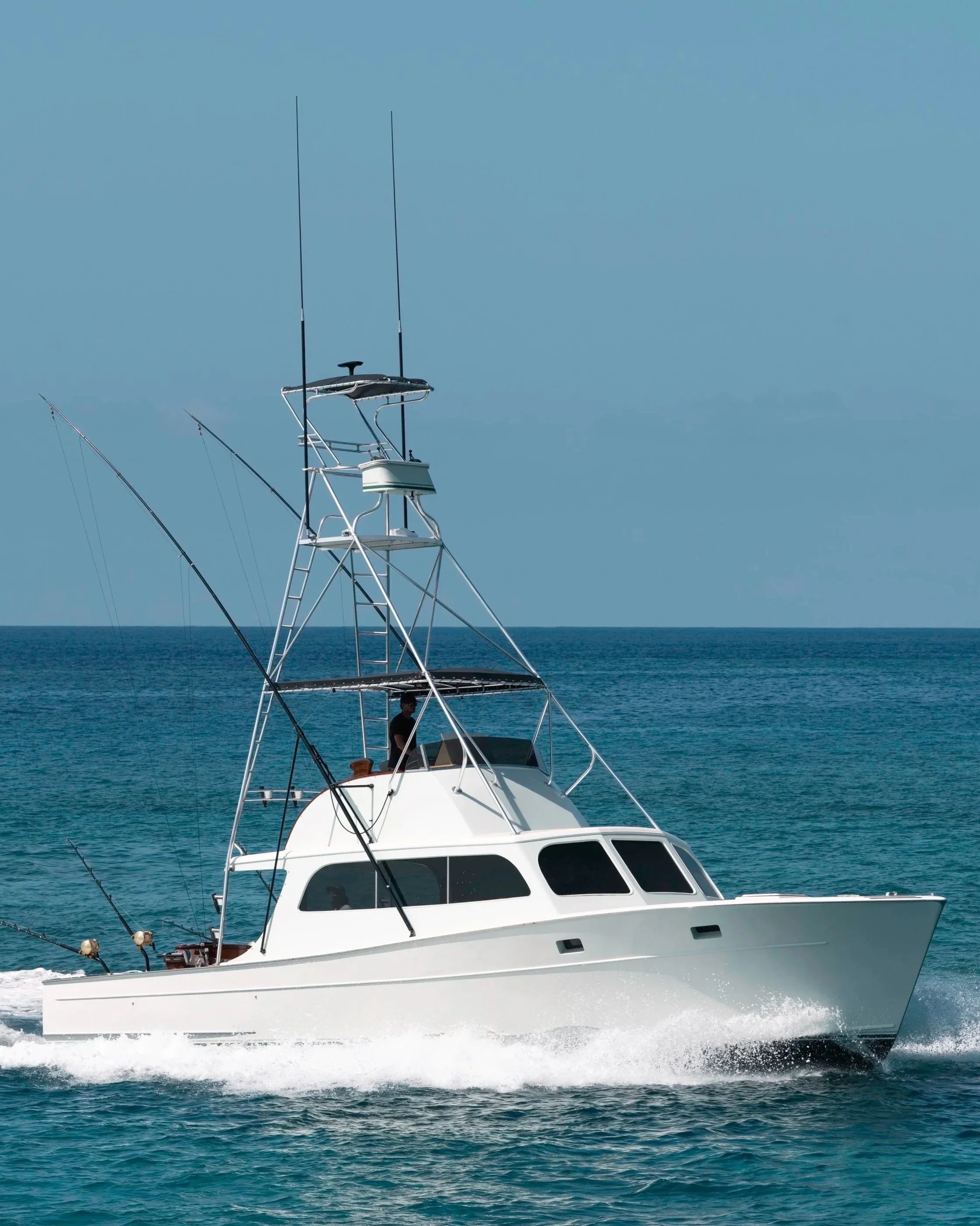 A boat named 'HUNTRESS' driving on the ocean.