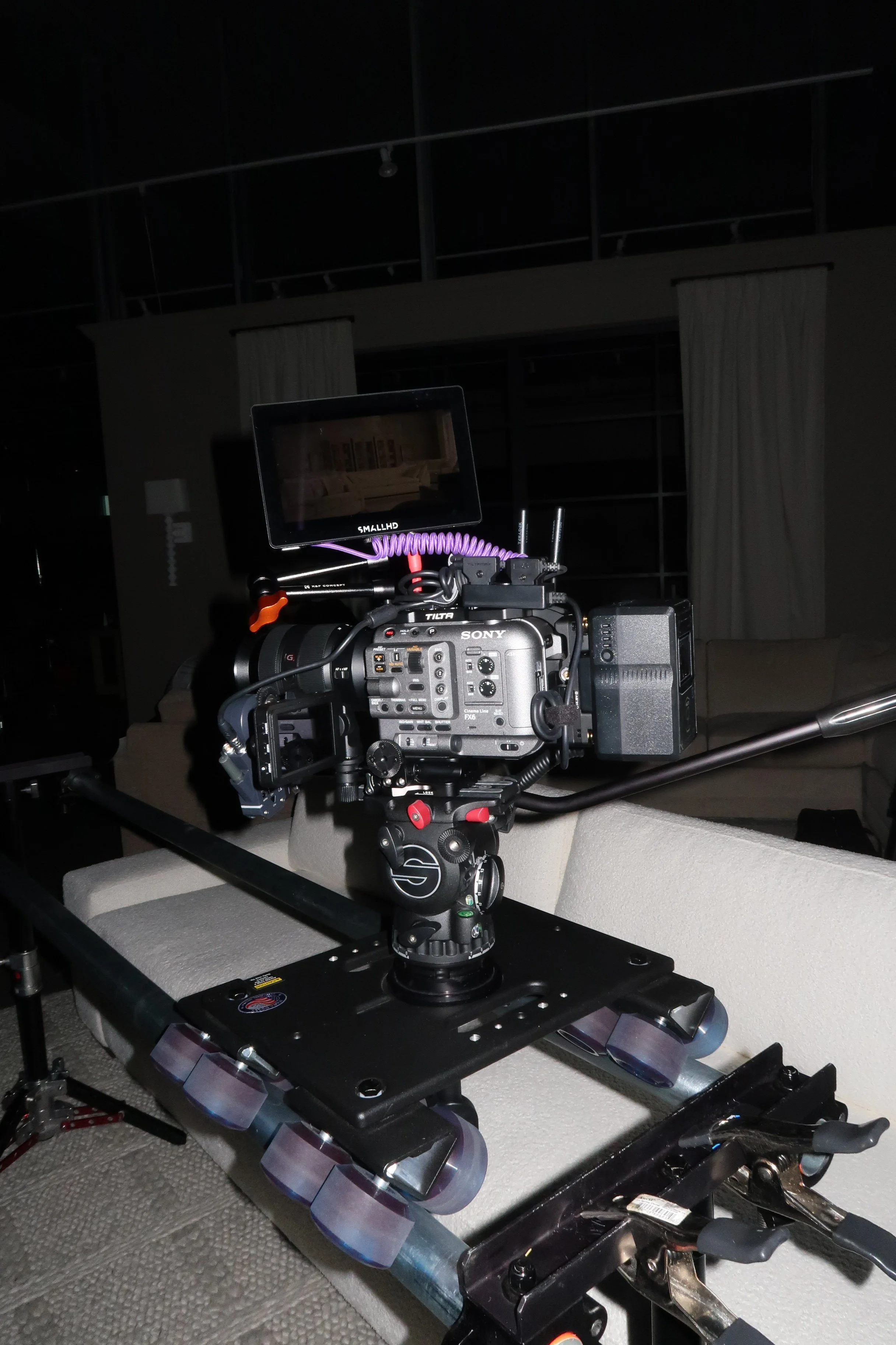 Cinematic camera setup on a dolly with a monitor in a living room.
