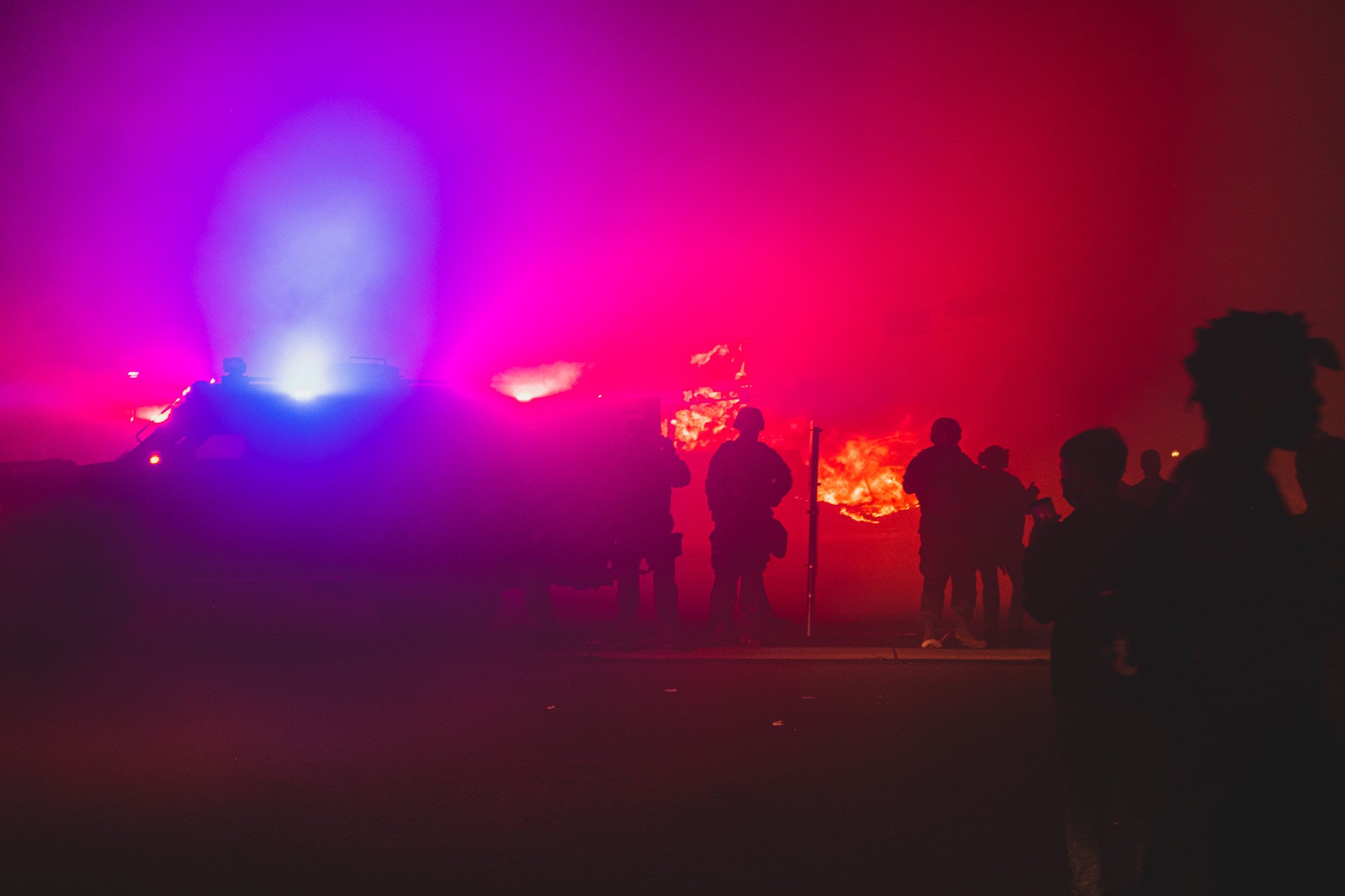 Three table spoons of color, four cups of smoke, seven silhouettes, two burning businesses, a riot control vehicle. Kenosha bleeding color. 
