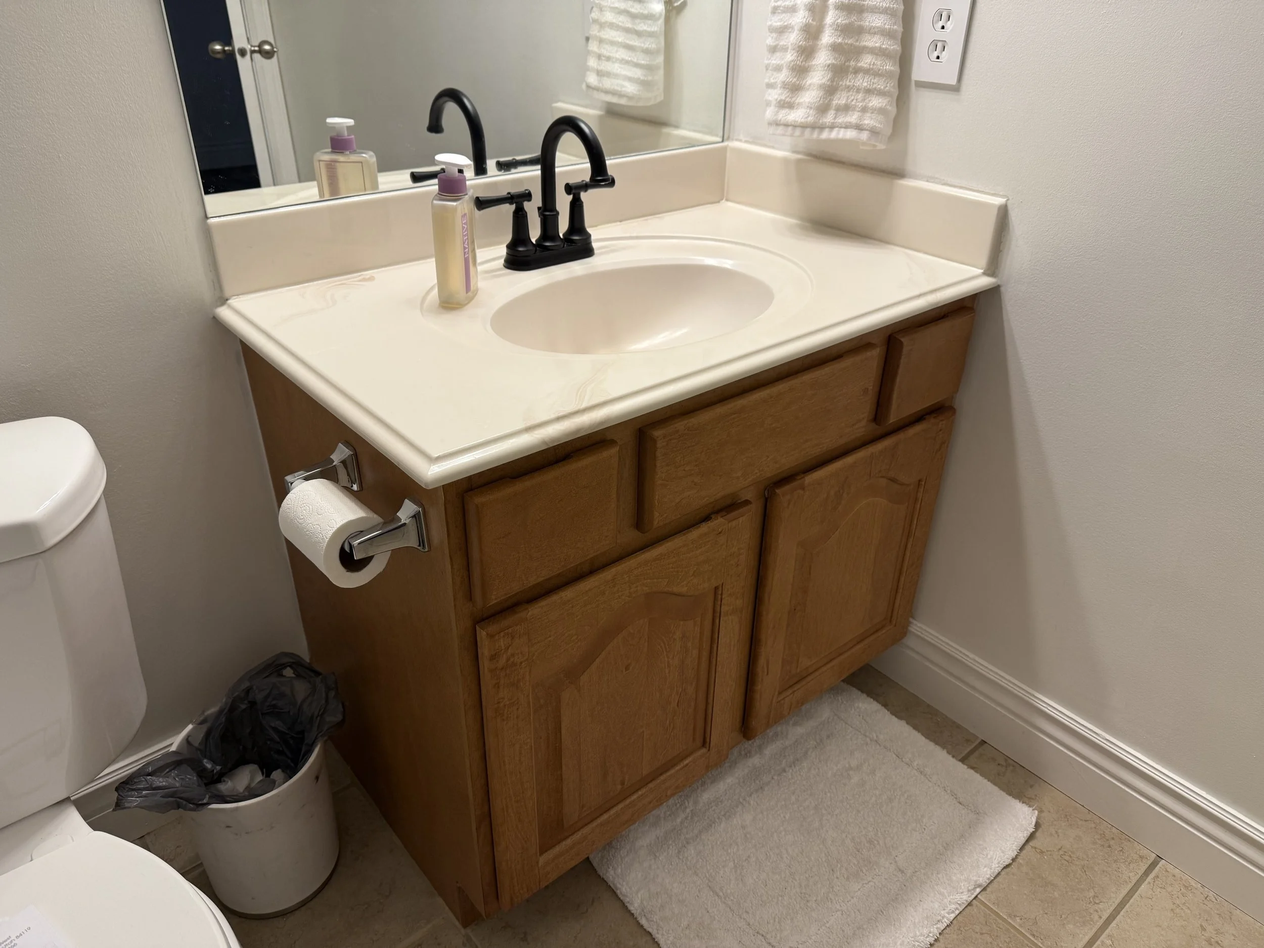 Original wood bathroom vanity in North Salt Lake before cabinet refacing and quartz countertop replacement