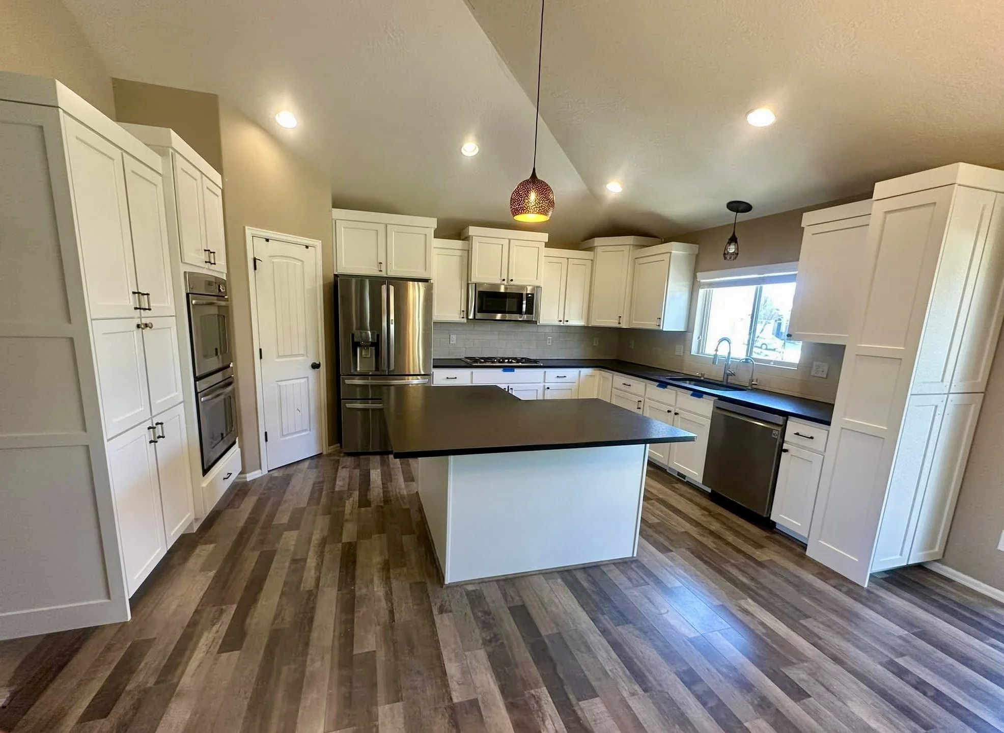 Professional cabinet refinishing with smooth spray finish, new trim, and soft-close hinge installation