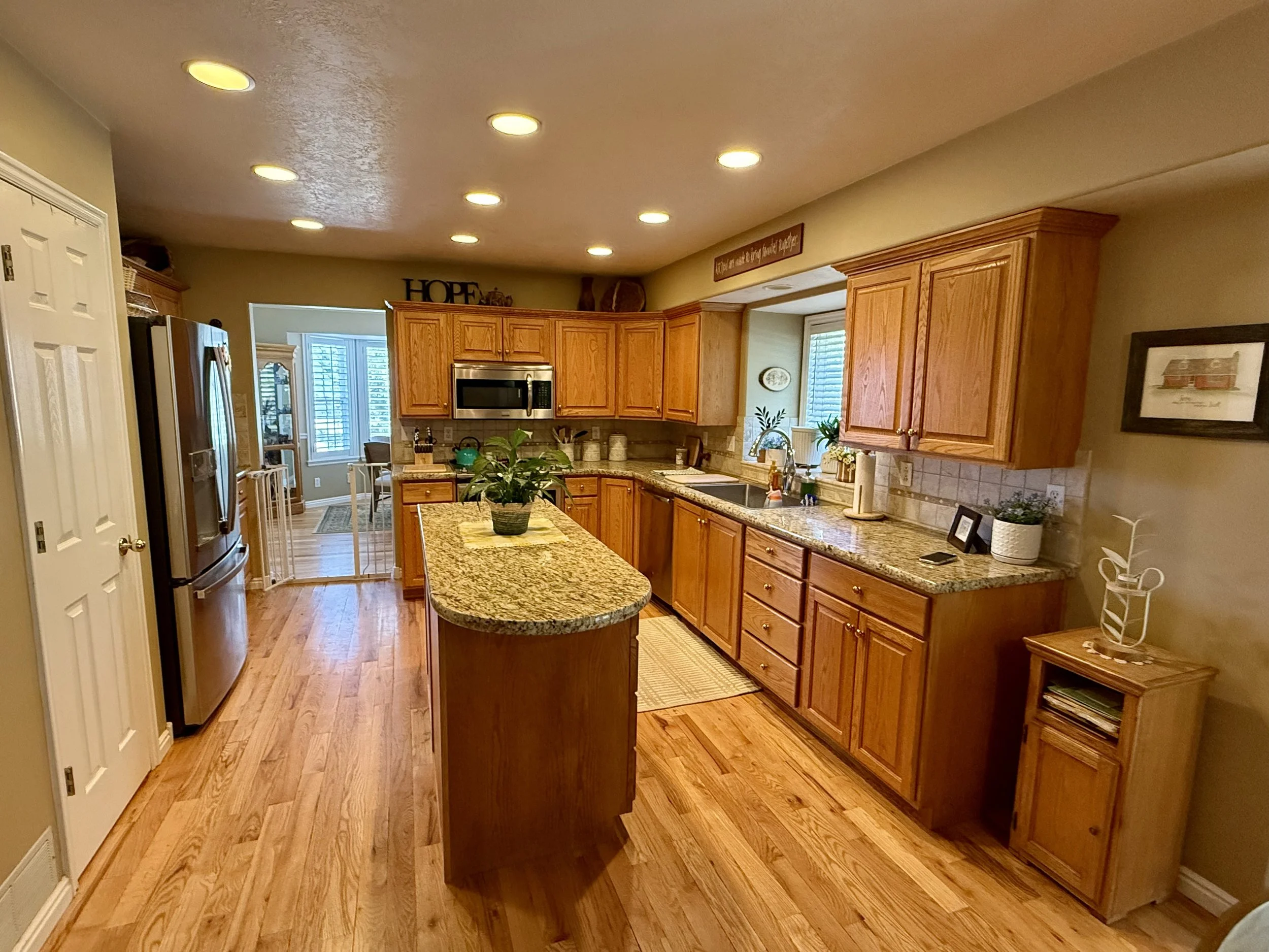 North Salt Lake, Utah kitchen before cabinet refinishing with orange toned stained wood cabinets