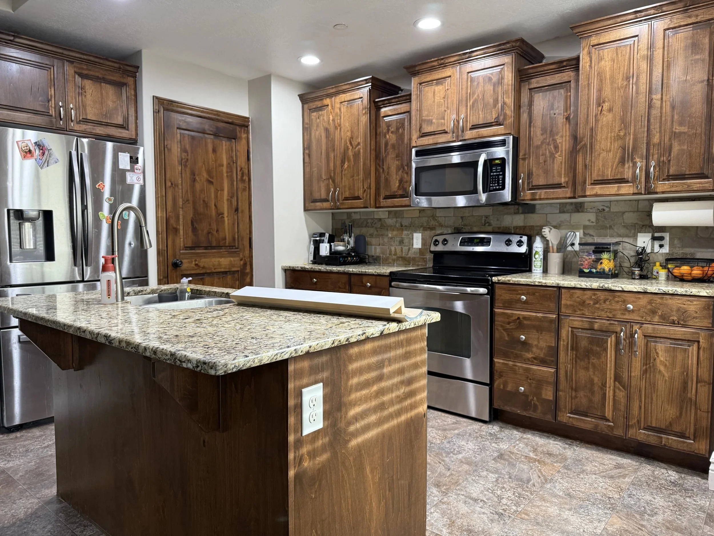 Kitchen with dated wood cabinets prior to modernization