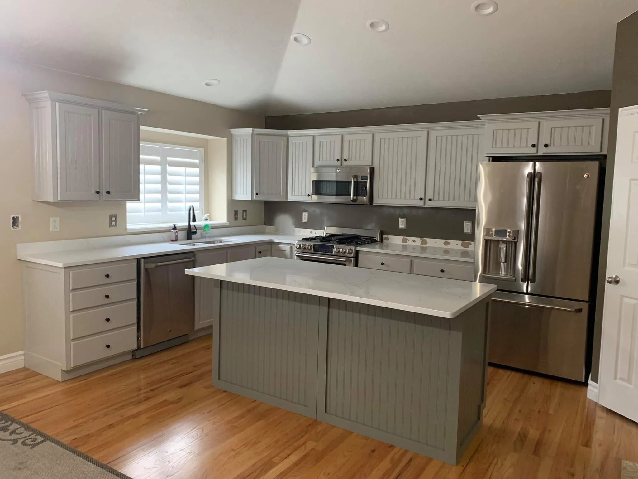 Two-tone kitchen cabinet refinishing with updated trim around island