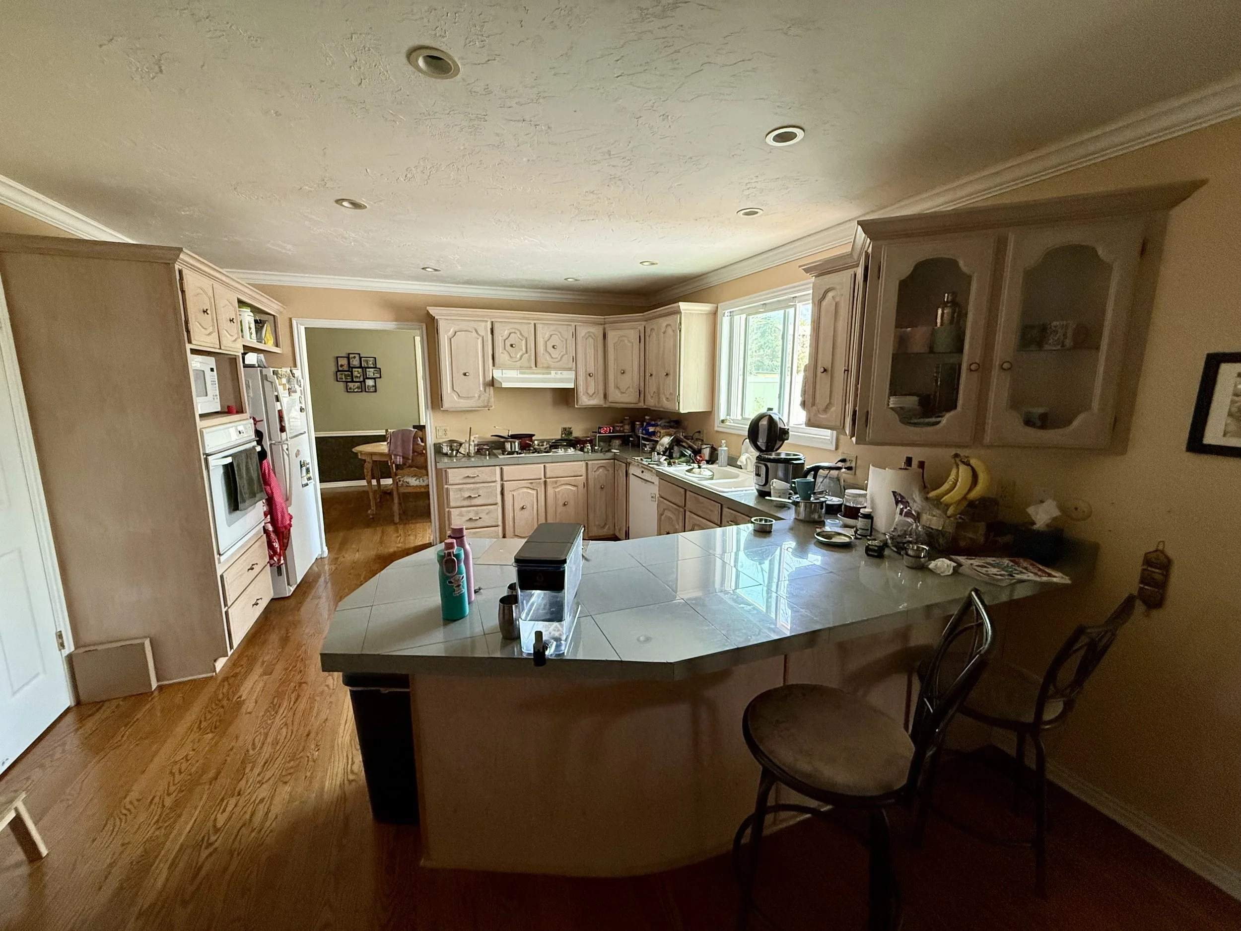 Sandy, Utah kitchen before cabinet refinishing with dated cabinet doors and tile countertops