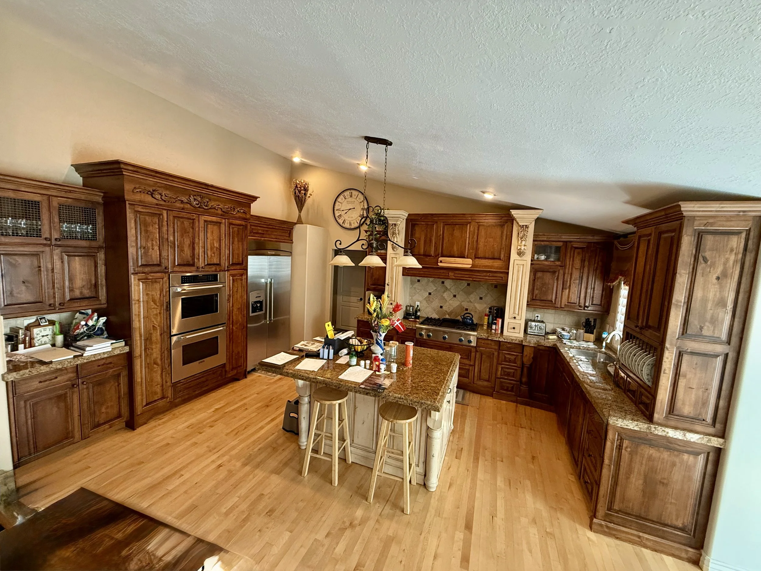 Bountiful, Utah kitchen before cabinet refinishing with worn stained wood cabinetry