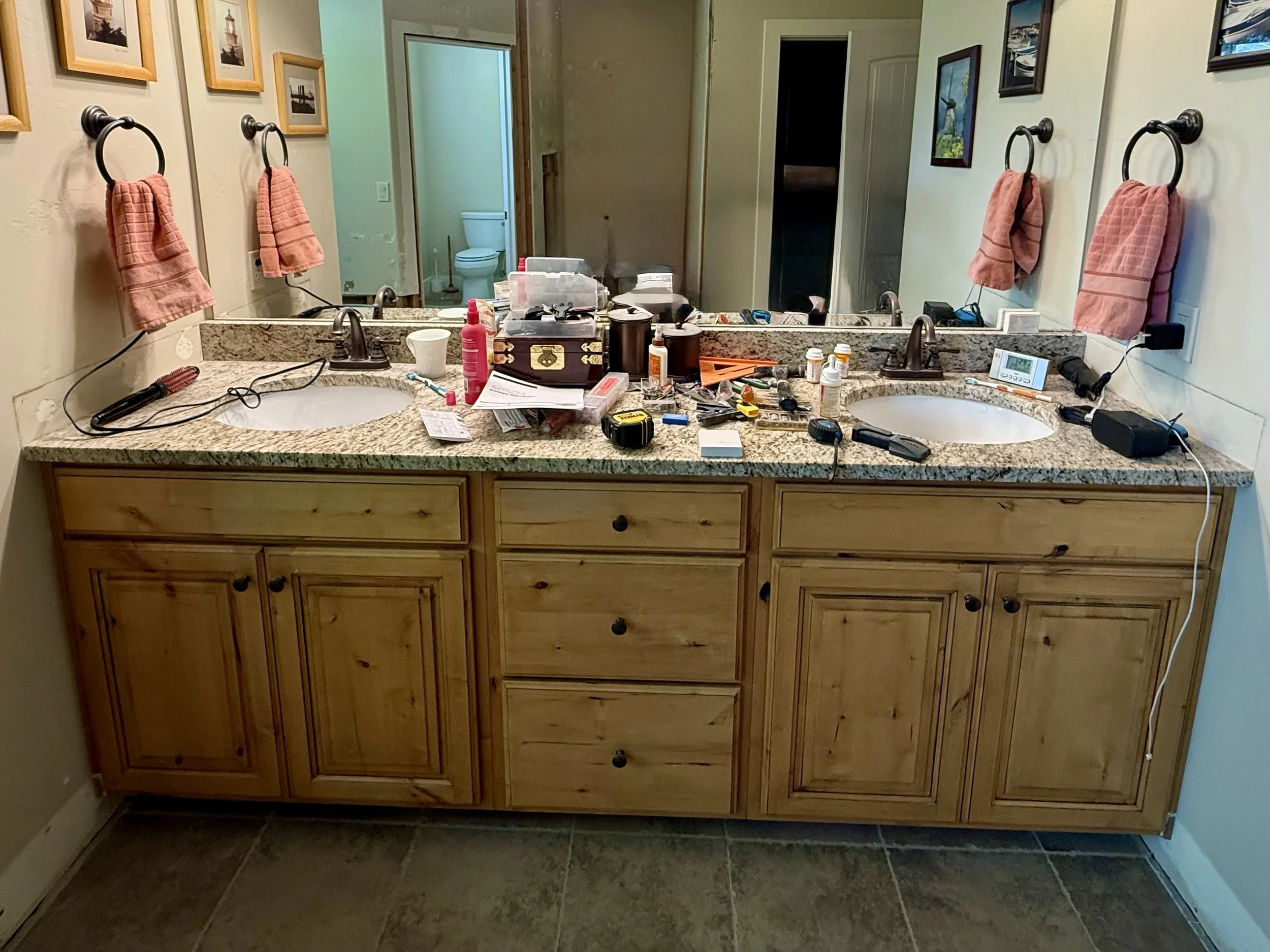 BEFORE | Pleasant Grove, Utah bathroom vanity before cabinet refinishing, featuring dated yellow-toned wood cabinetry, a matching mirror frame, and the original granite countertop.