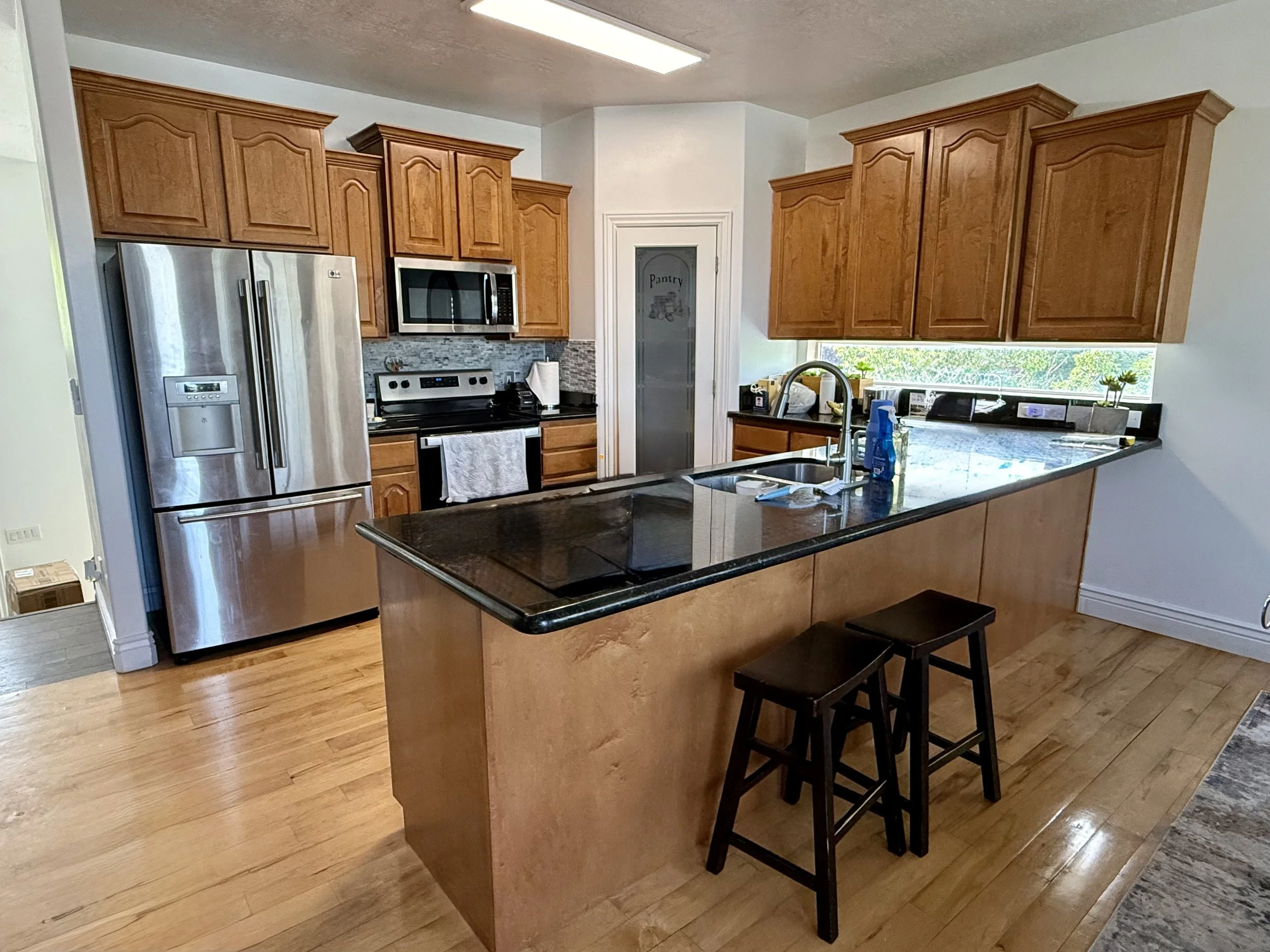 North Salt Lake, Utah kitchen before cabinet refinishing with stained wood cabinets and raised panel doors
