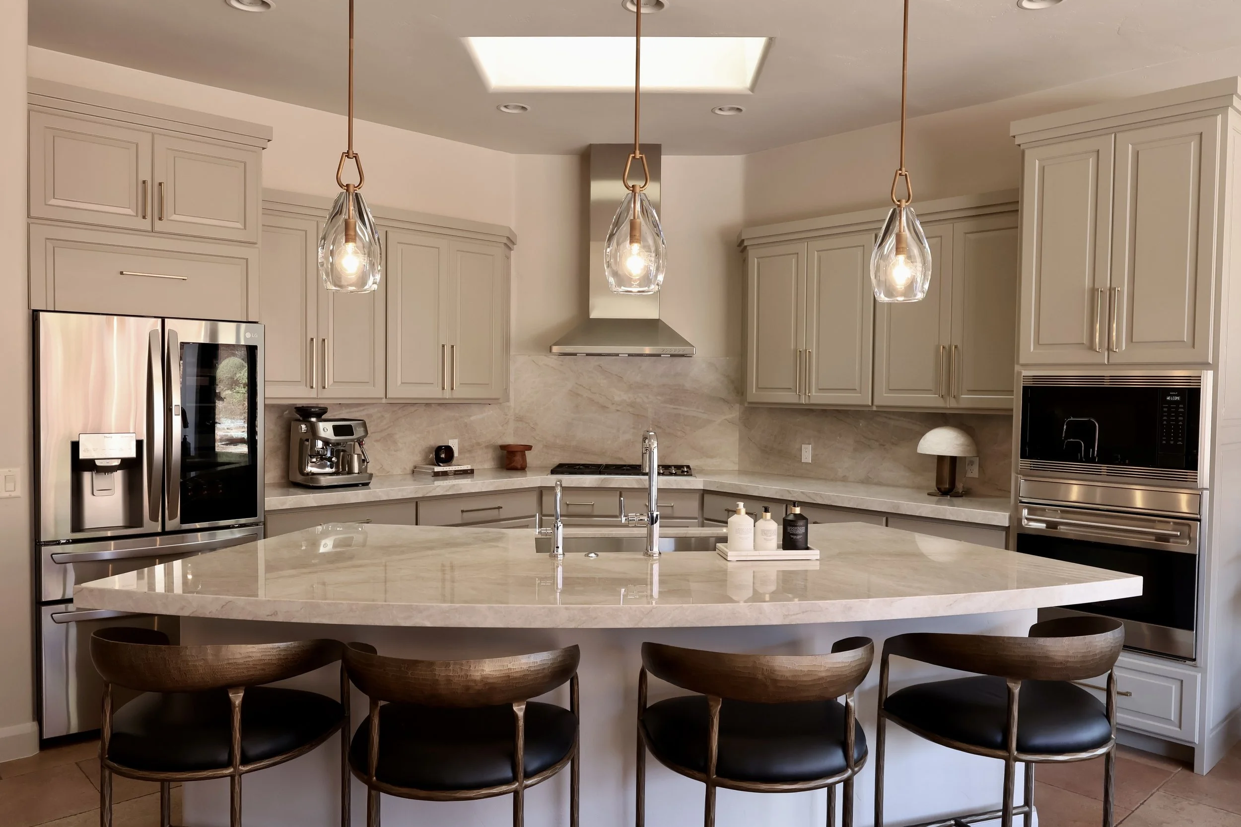 Refinished kitchen cabinets in St. George, Utah with Taj Mahal quartzite countertops, full-height quartzite backsplash, and custom cabinet pulls