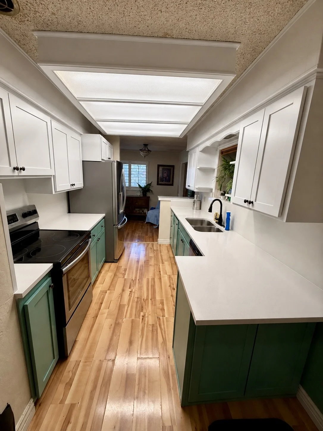 Kaysville, Utah kitchen after cabinet refinishing with new Shaker doors, two tone cabinetry, quartz countertops, and full height backsplash
