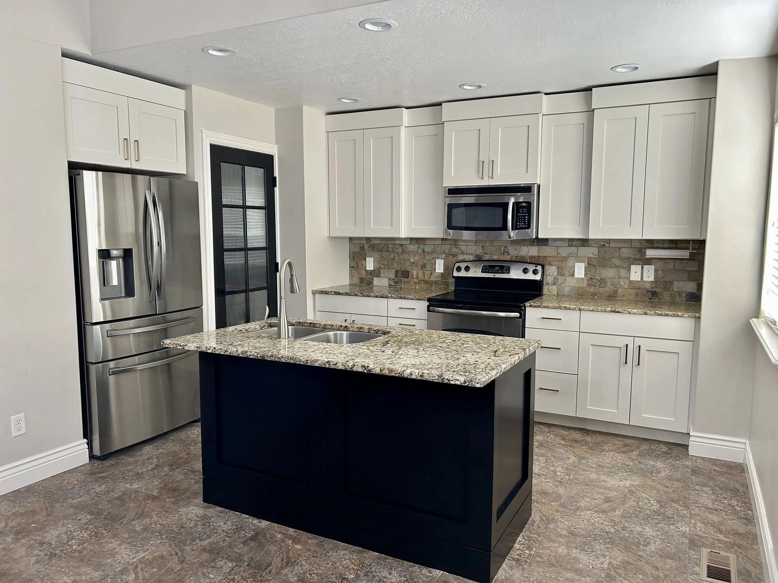 Cabinet door replacement with factory-finished doors and updated trim detail in Wasatch Front home