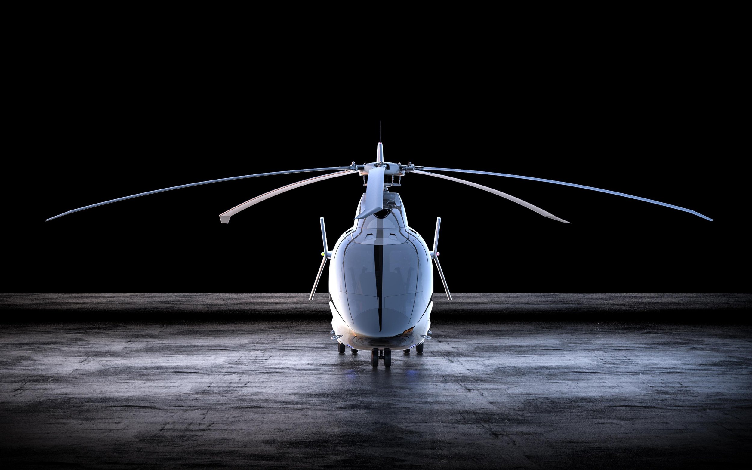 A helicopter on a dark tarmac with bright lighting focused on the front, showcasing its front view and rotor blades.
