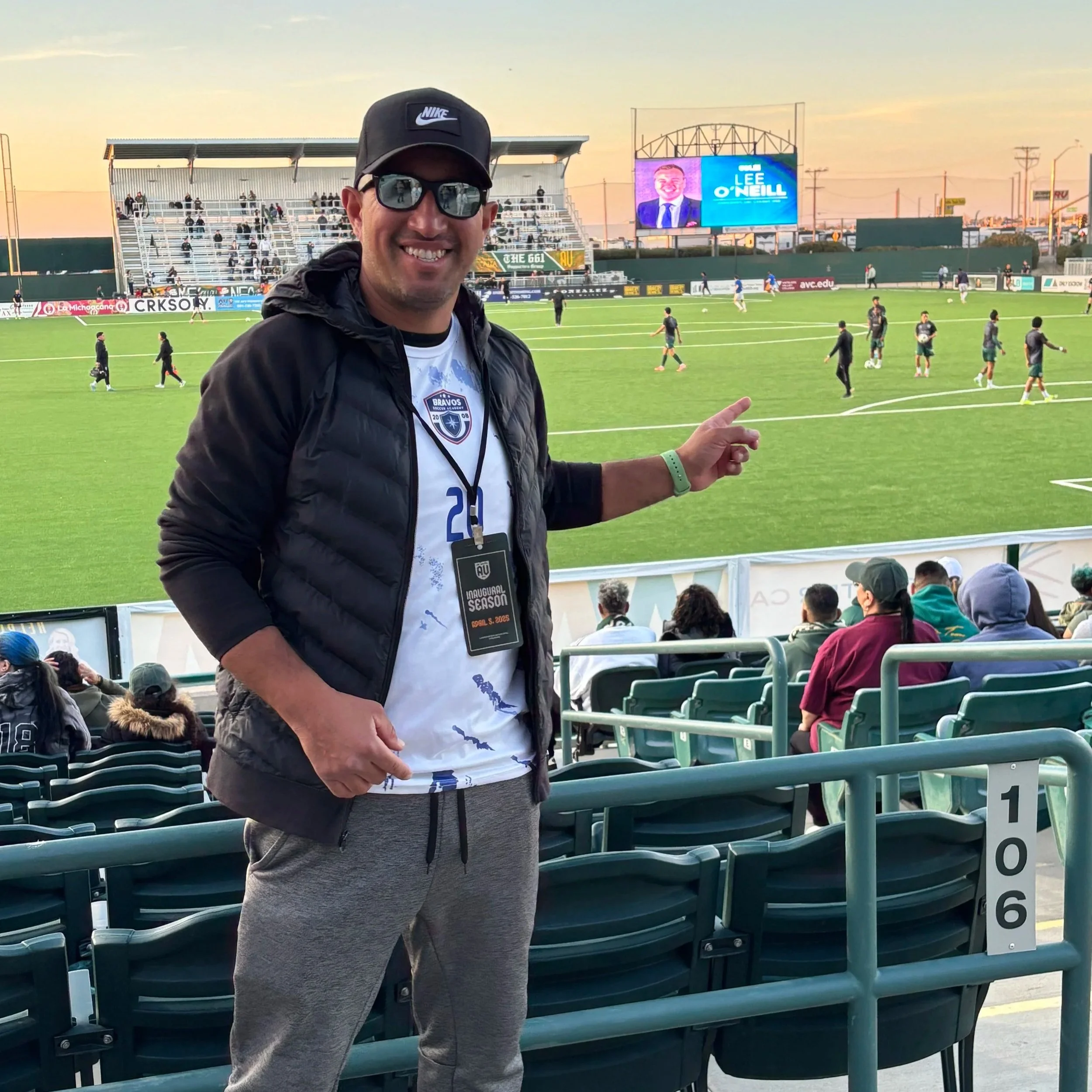 Gerardo Bravo smiling and pointing at a soccer field in Lancaster watching AVFC play there first ever game