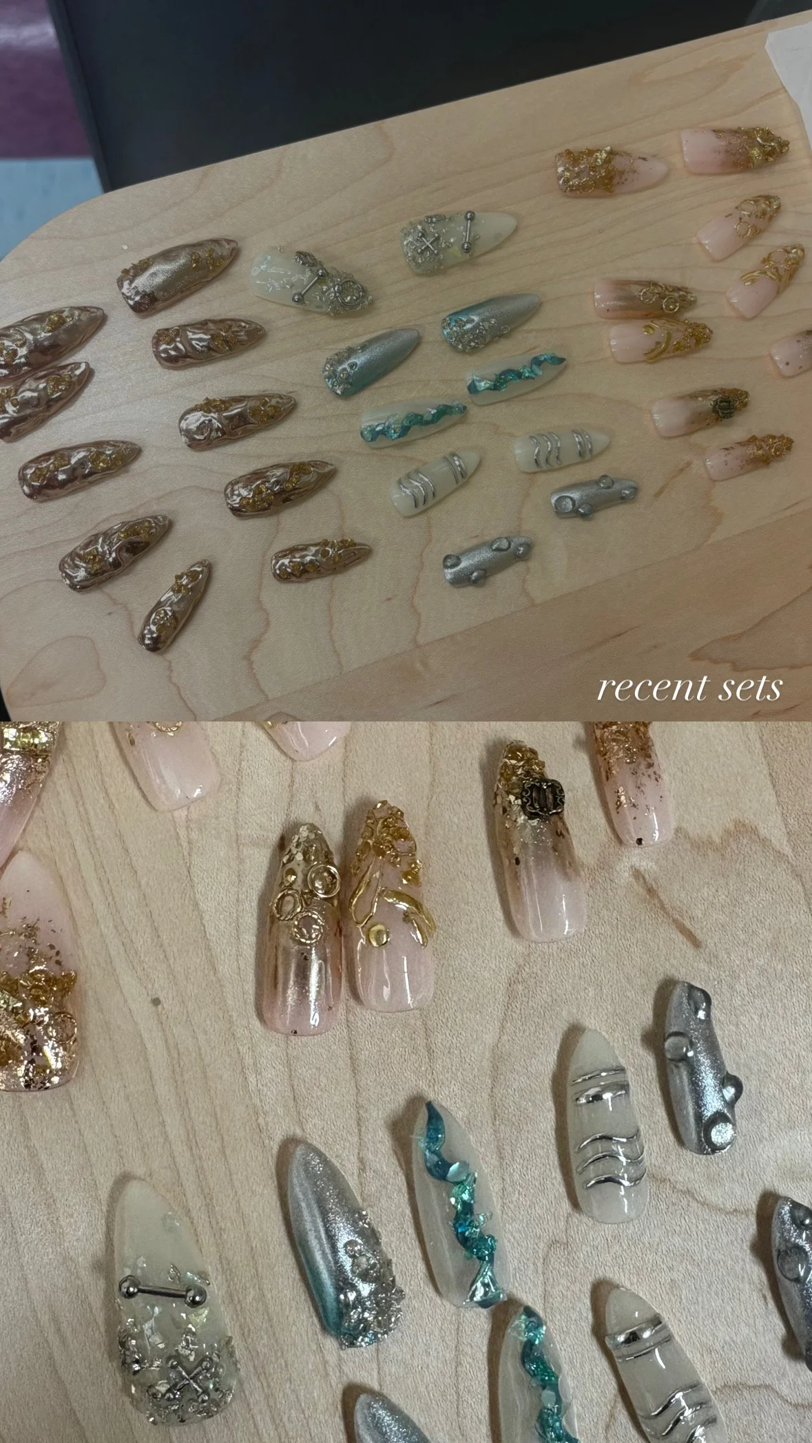 Assorted decorative nail art designs with various colors and embellishments displayed on a wooden surface, labeled as "recent sets."