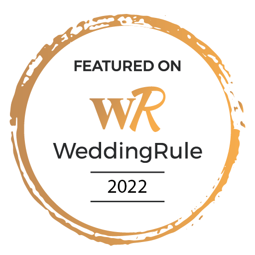 A circular badge with a gold brushstroke border, featuring the text 'FEATURED ON WeddingRule 2022' and the WeddingRule logo.