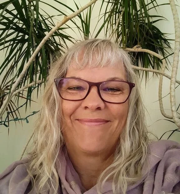 a photo of registered psychologist Karen williams smiling with plant in the background